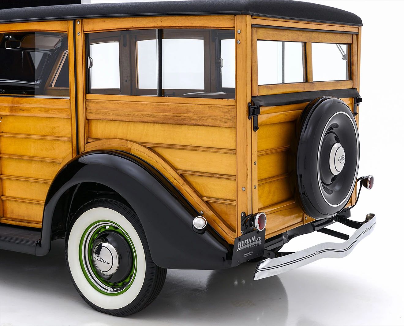 Rear section of the body of a 1936 Ford wood-bodied station wagon against a white background