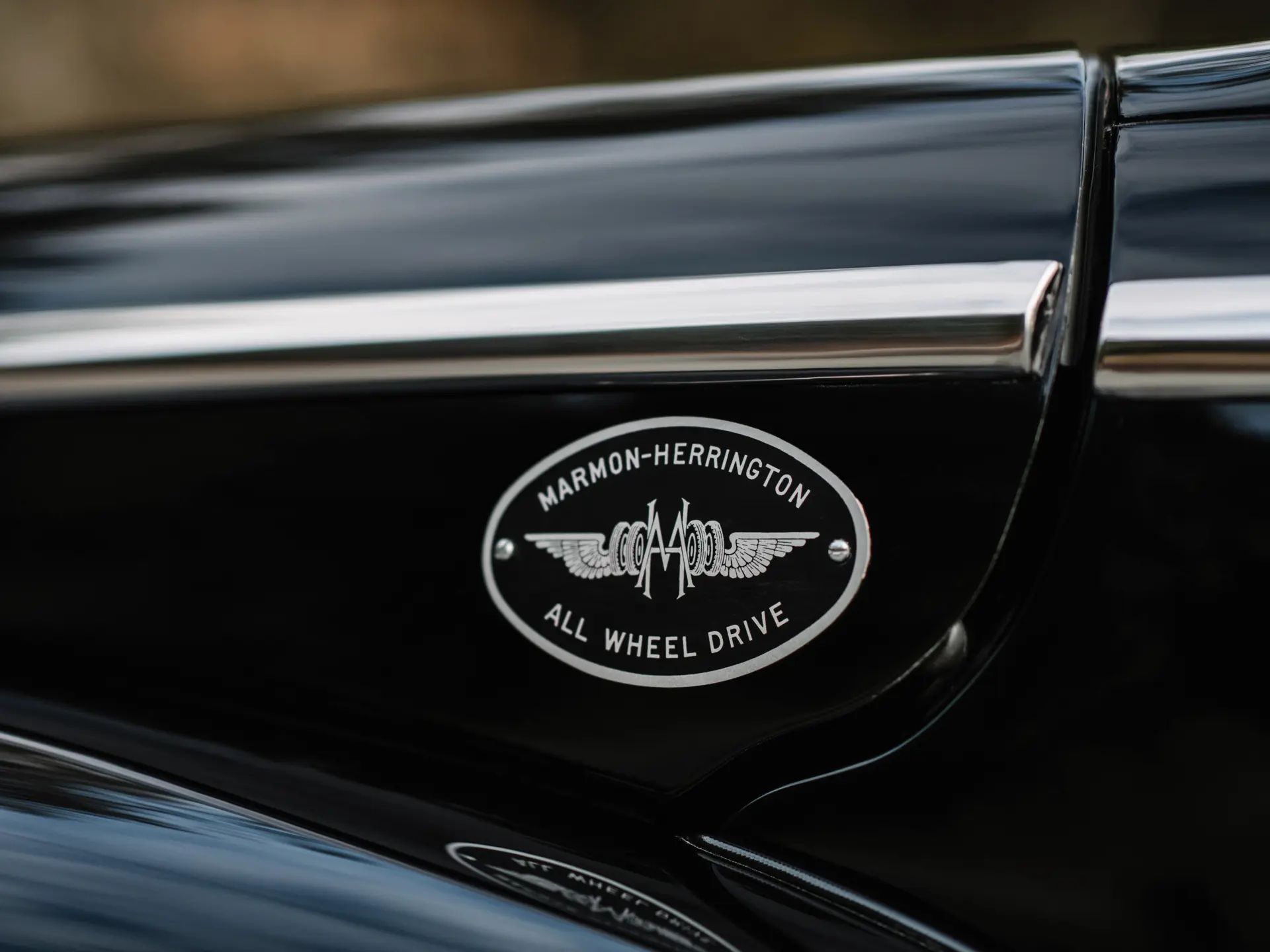 Marmon-Herrington badge on a black 1947 Ford station wagon