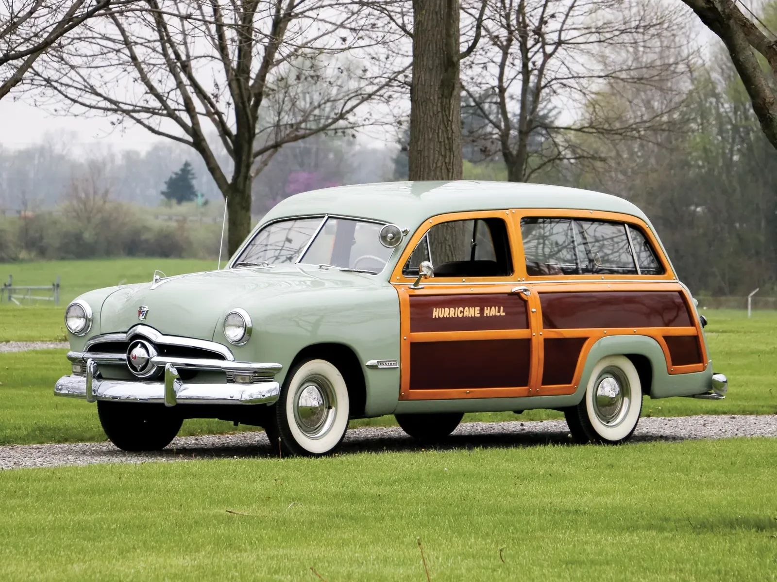 Left front 3q view of a light green 1950 Ford station wagon with the words "Hurricane Hall" on the door