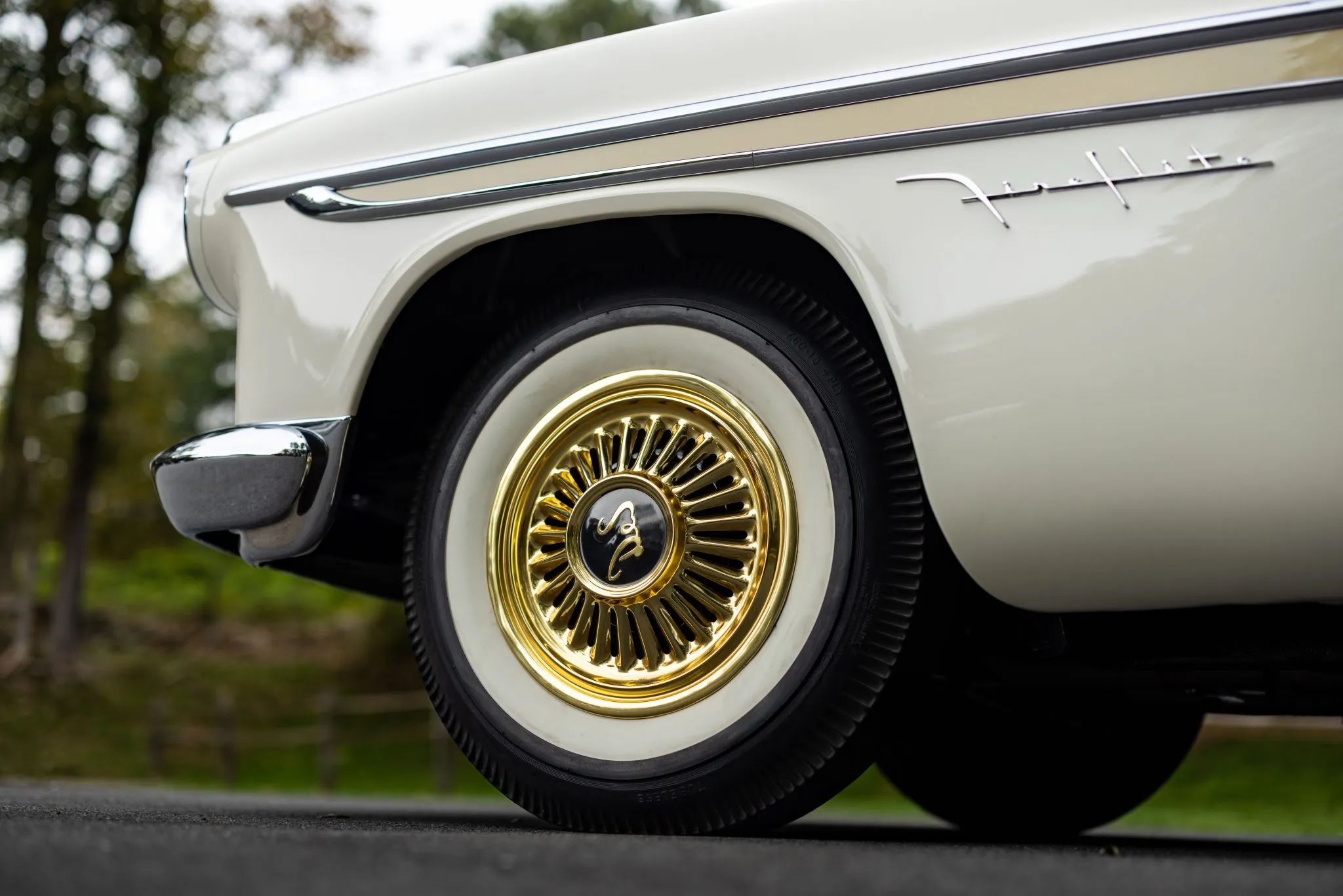 Front wheel of a 1956 DeSoto with gold wheel covers