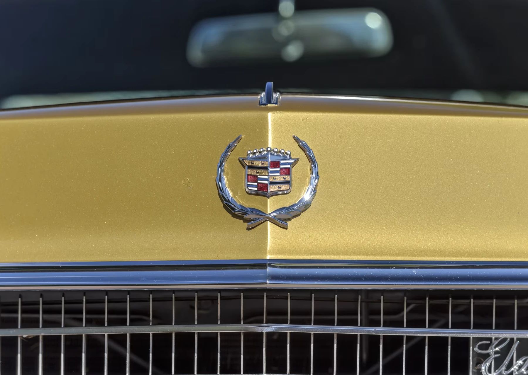 Vintage C/D Review: 1970 Cadillac Eldorado Was Powerful, Pricey, and Prestigious – So, Why Did They Photograph It Outside A Check-Cashing Place? 4 Closeup of a Cadillac wreath and crest on the nose of a gold Eldorado