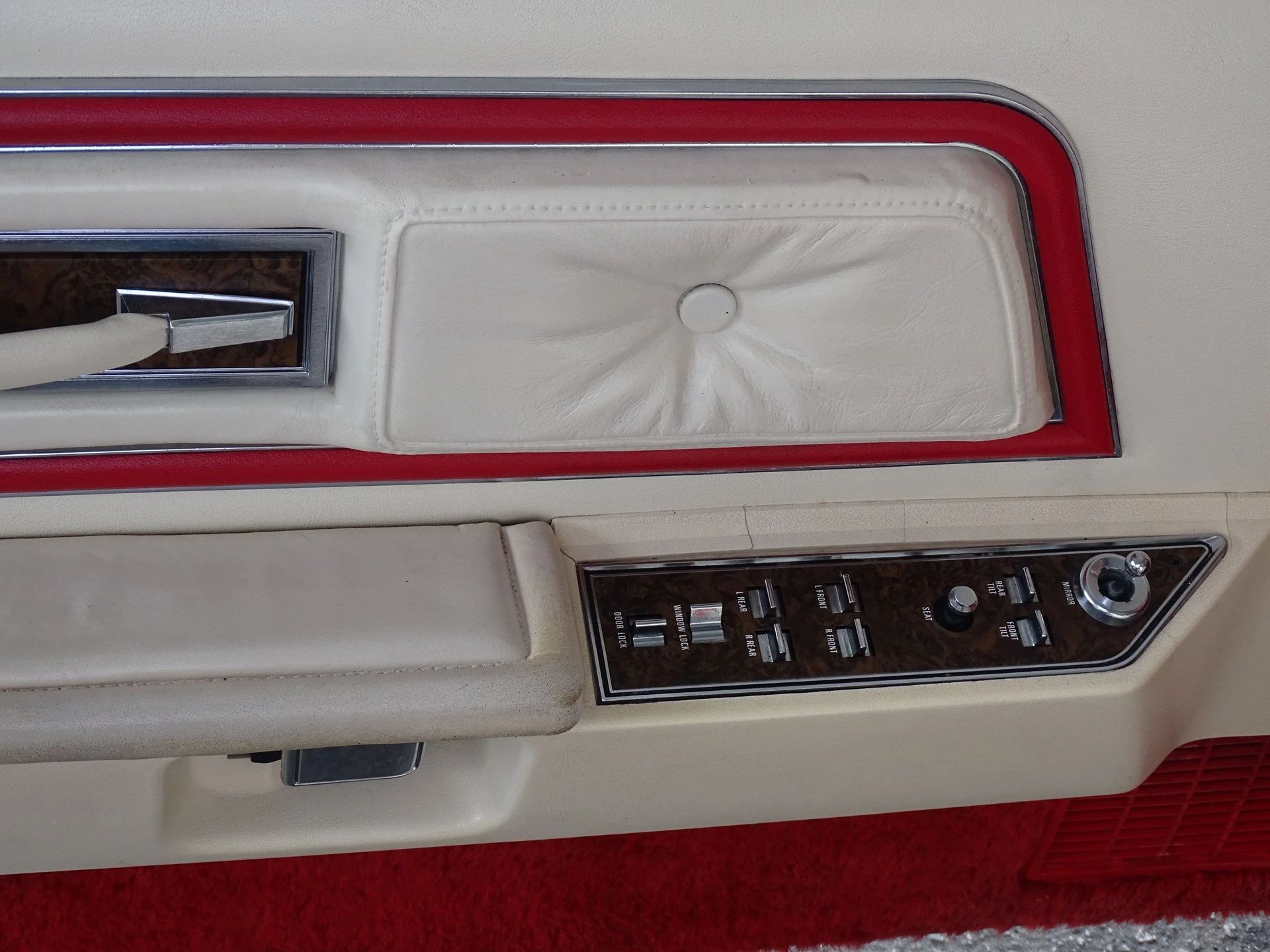 Closeup of driver's door panel of a 1975 Mark IV with Lipstick Red accents on white