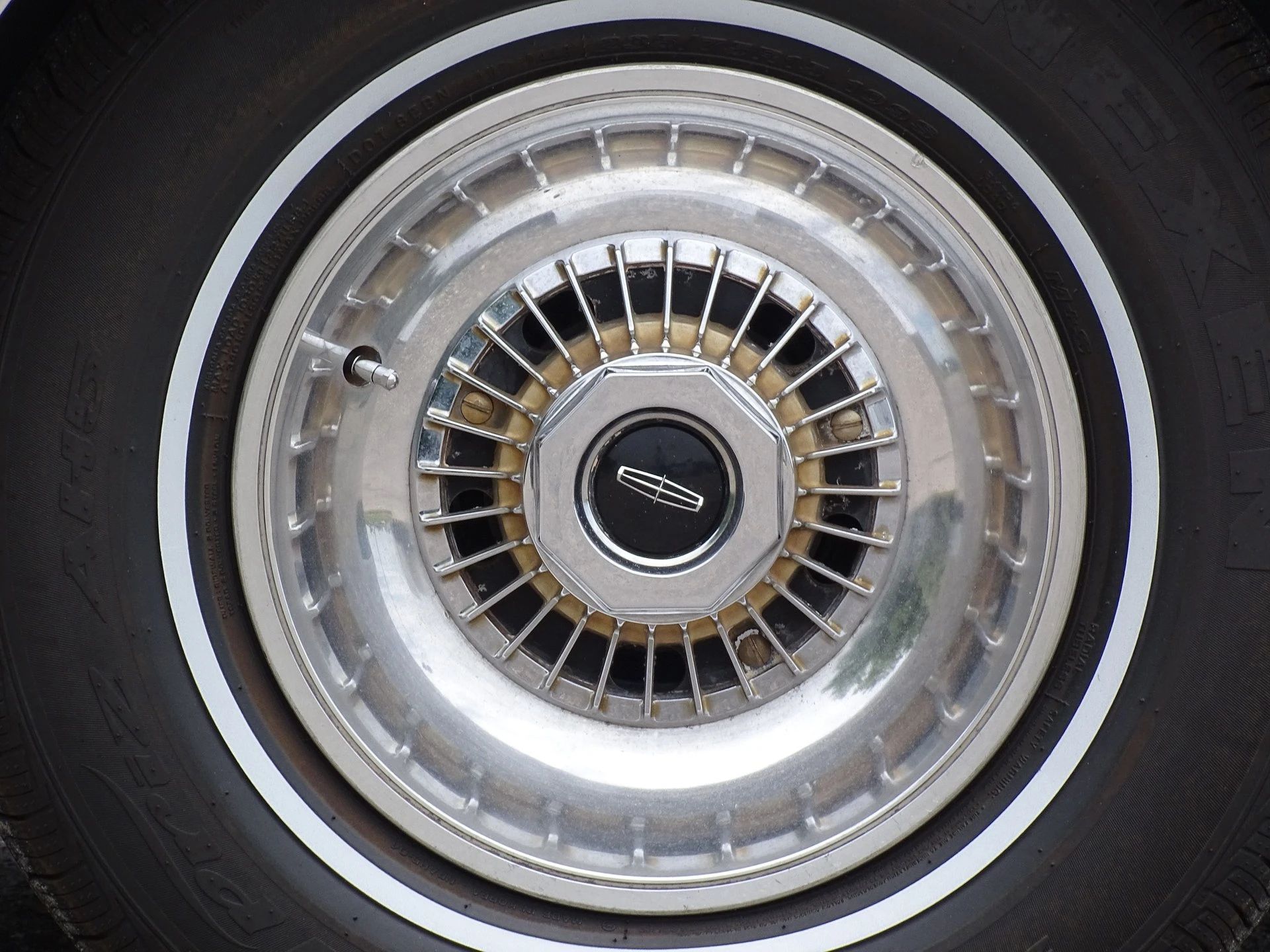 Close-up of a forged alloy wheel with a whitewall tire