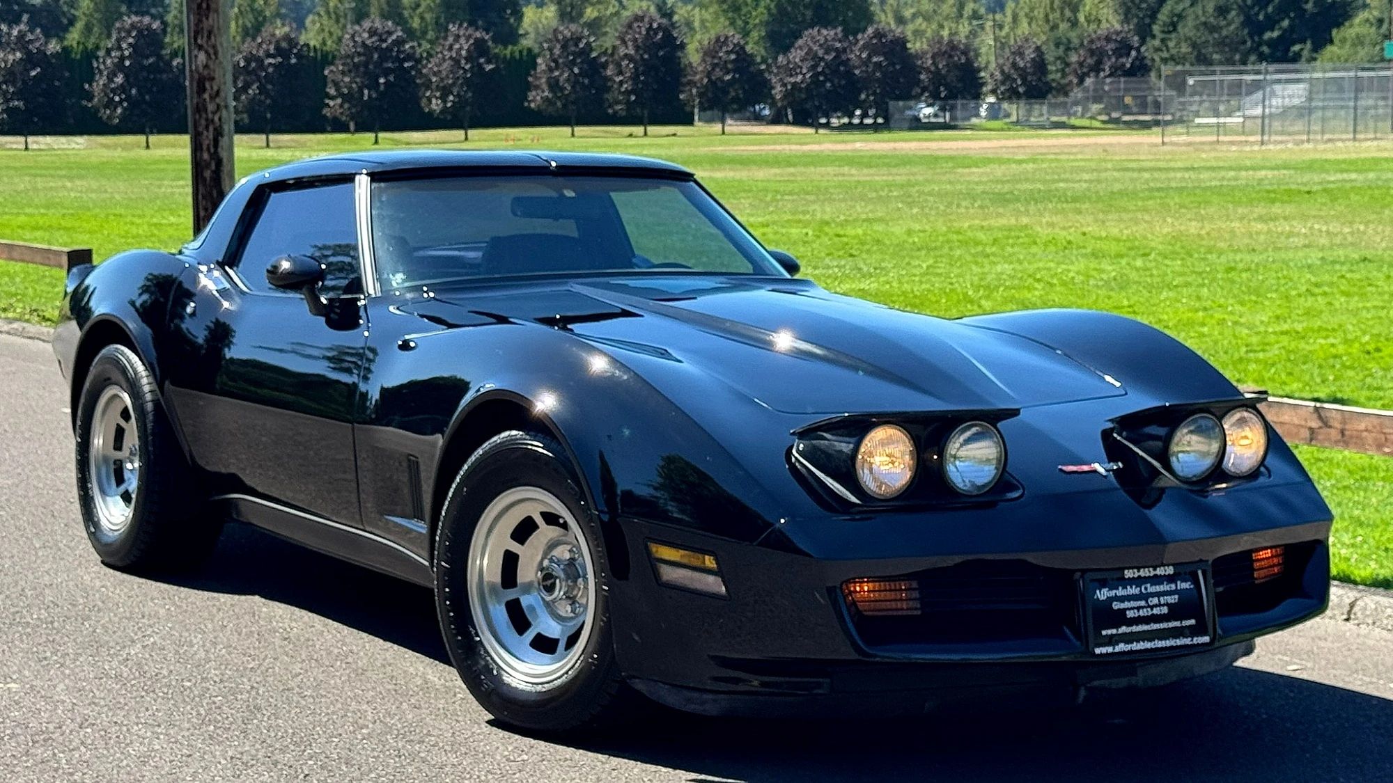 Right front 3q view of a black 1980 Chevrolet Corvette with its headlights on