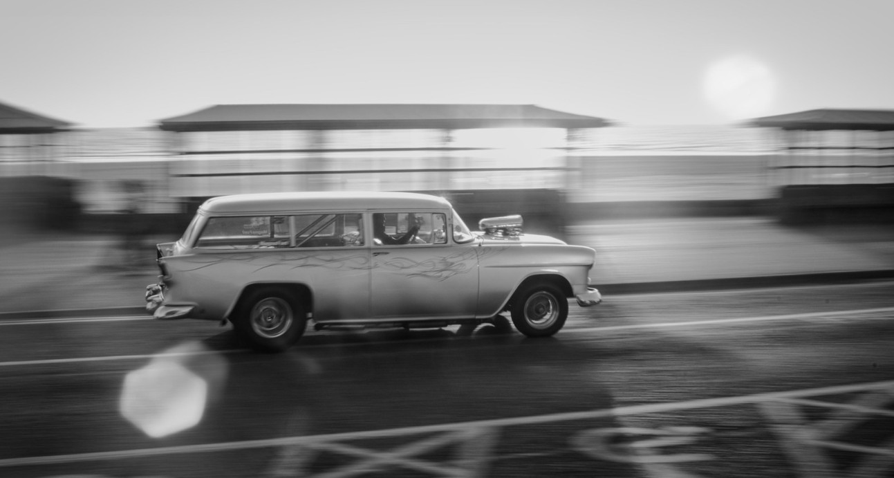 B&W photo of a modified Chevrolet station wagon with a supercharger on the hood