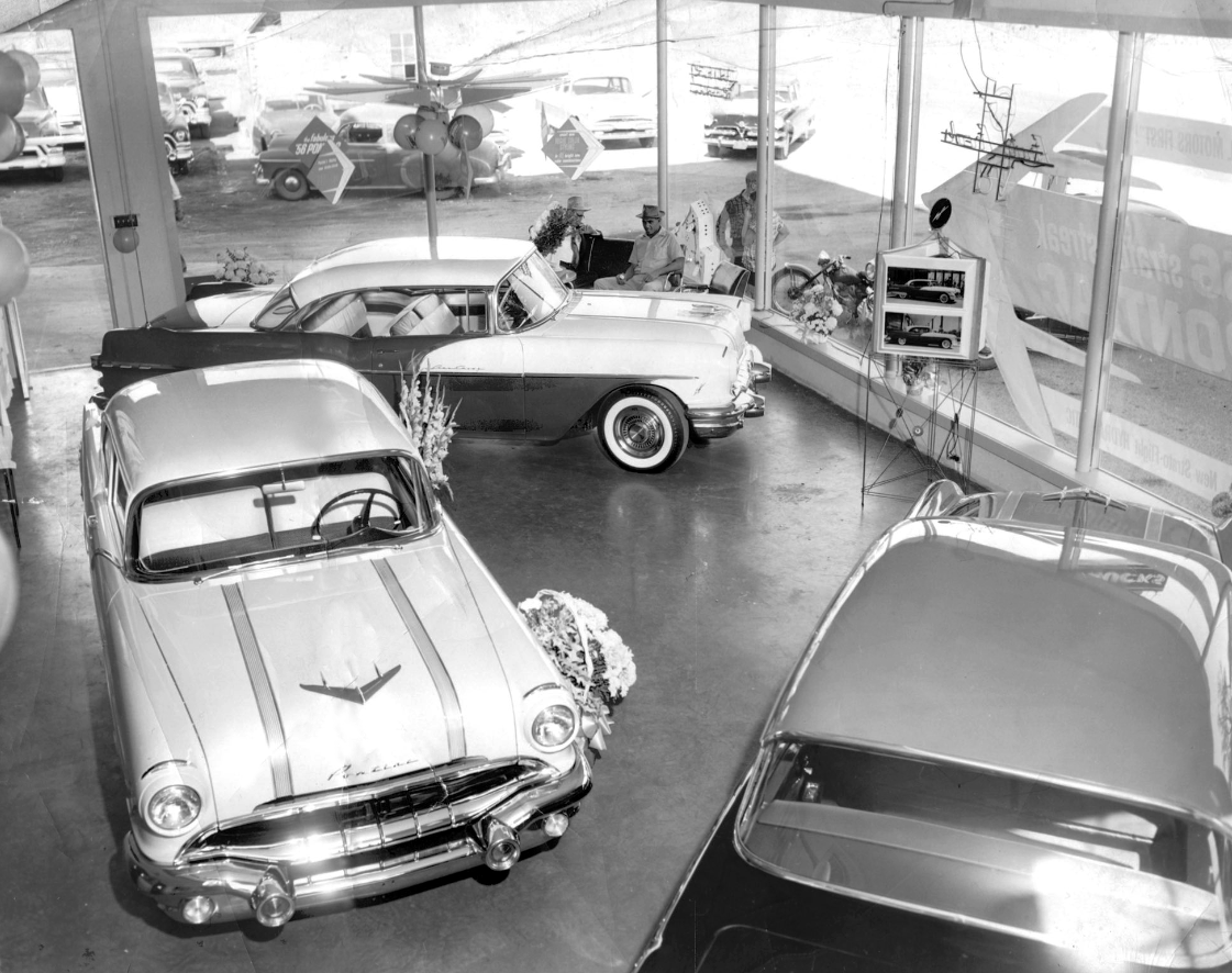 Inside GM's Golden Days: 1950s Dealership Showrooms In Vintage Photos 1 B&W photo of 1956 Pontiacs in a dealer showroom