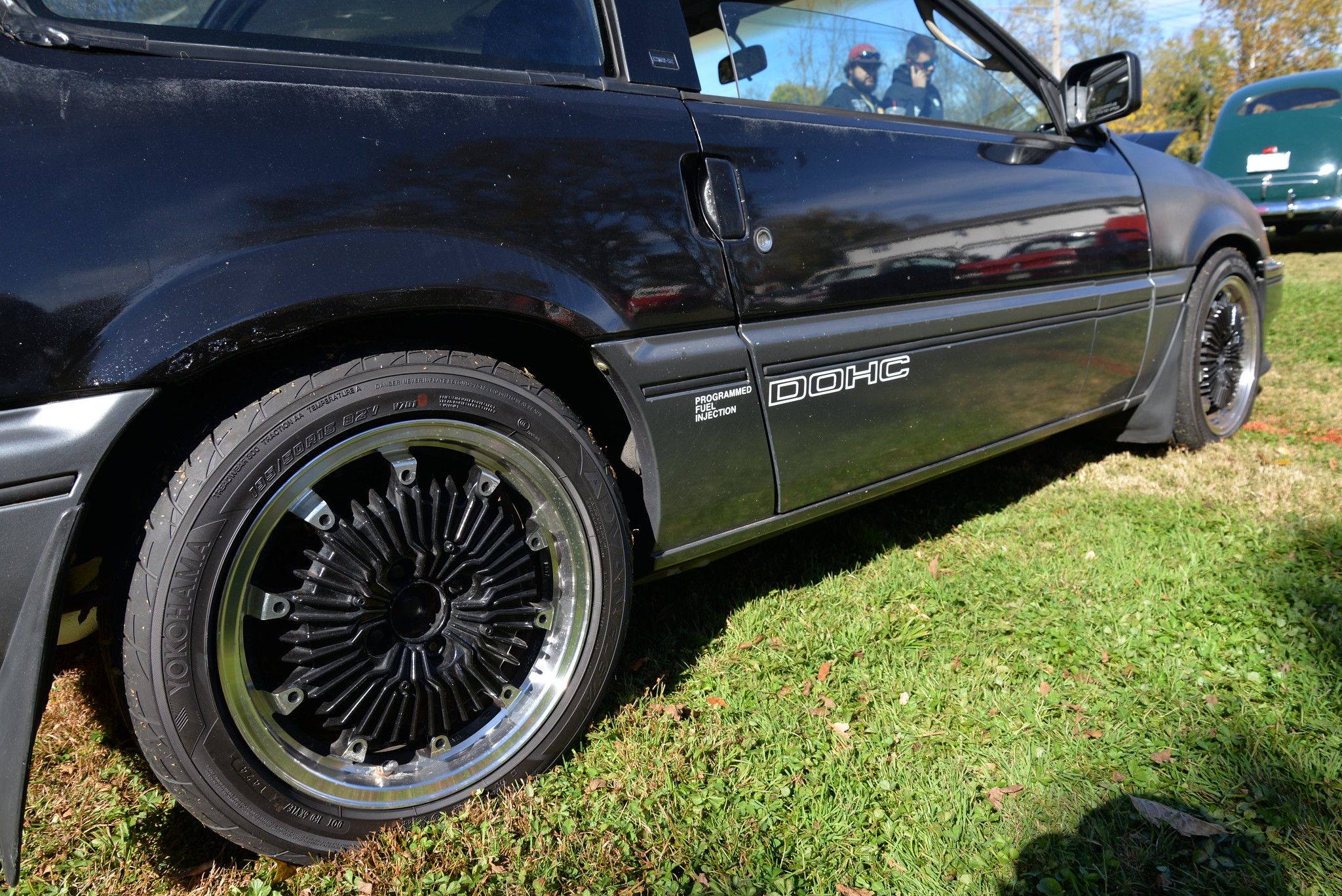 Right body side of a black 1985 CRX with "DOHC" lettering and Mugen wheels