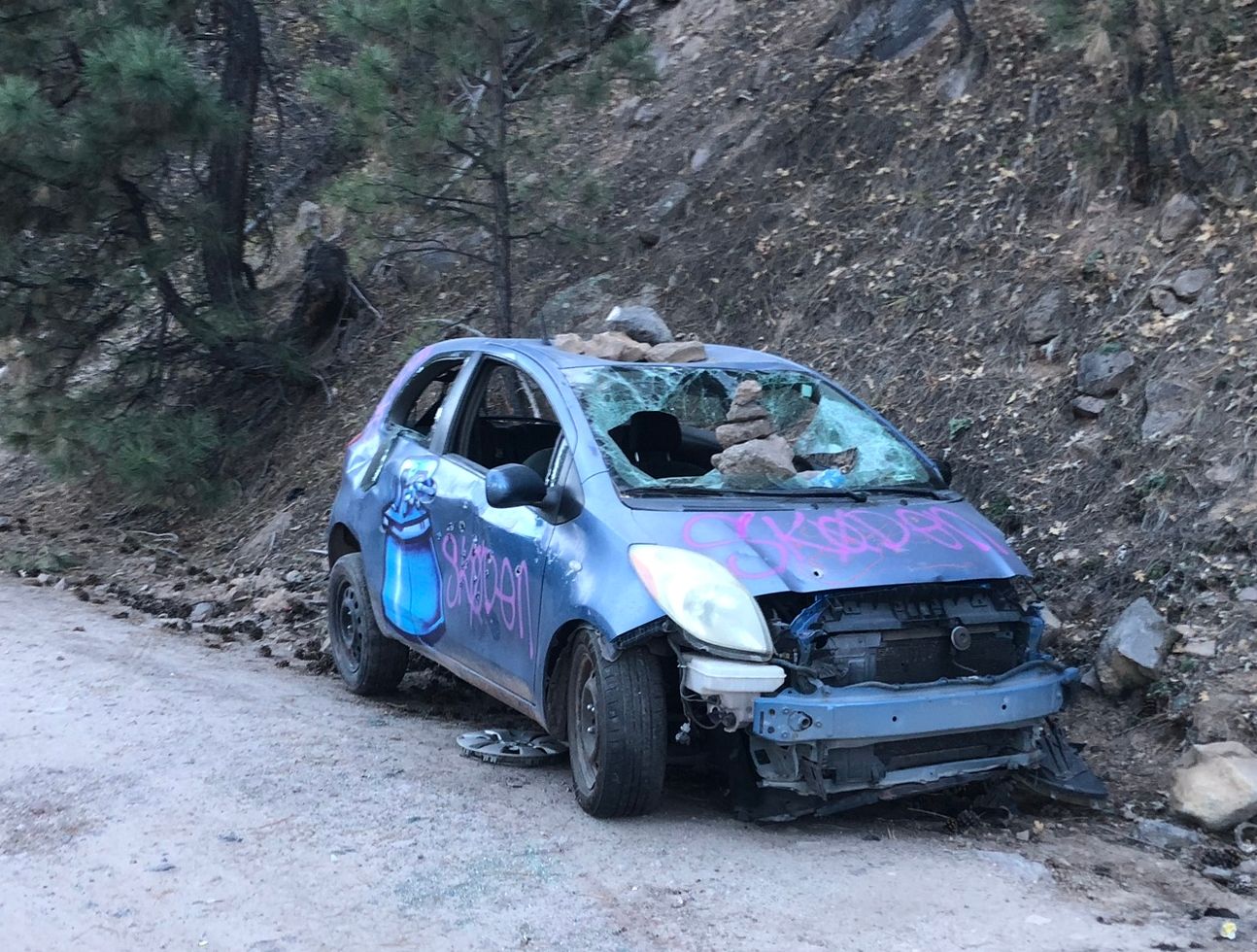 This Toyota Yaris Didn't Quite Make It To The Hot Springs 1 Very battered Toyota Yaris with a broken windshield, smashed windows, and lots of graffiti