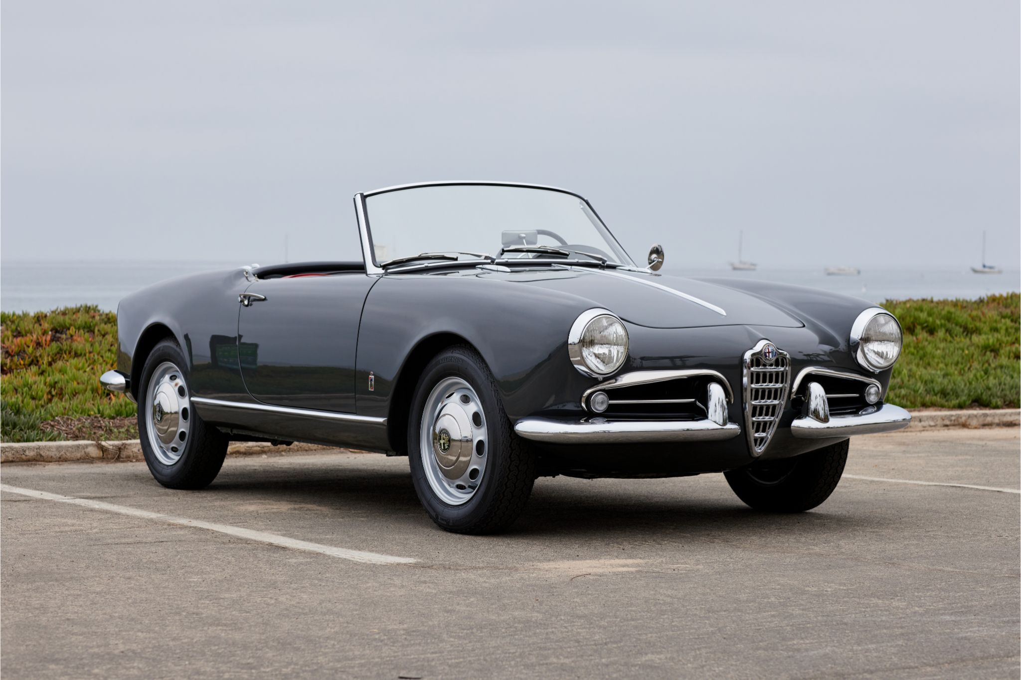 Picture of black 1959 Alfa Romeo Giulietta Spider in beach parking lot