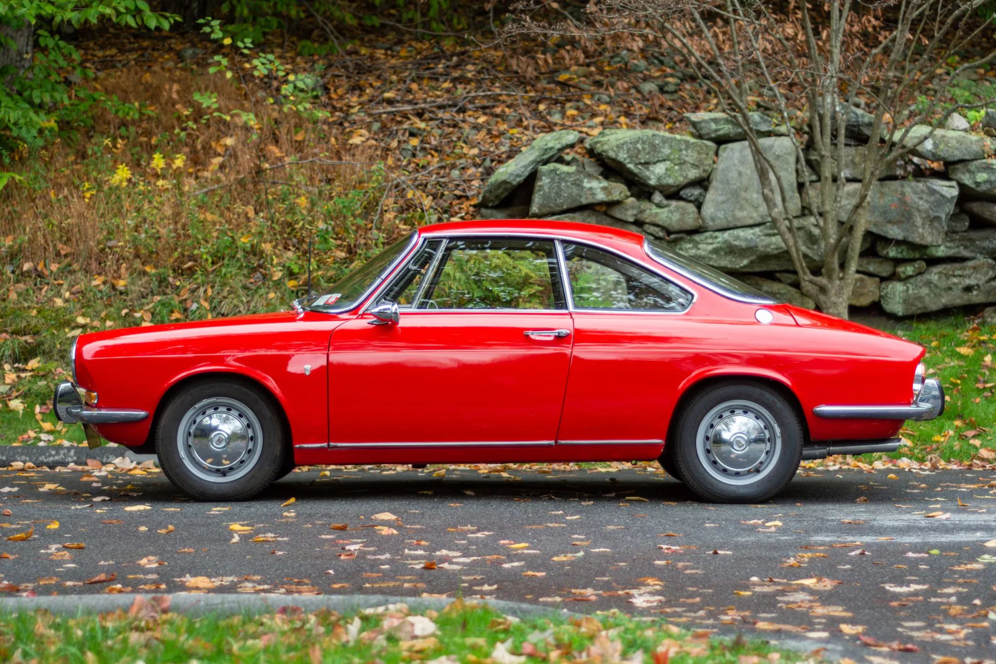 Image of red Simca 1000 Bertone Coupe in front of rock formation