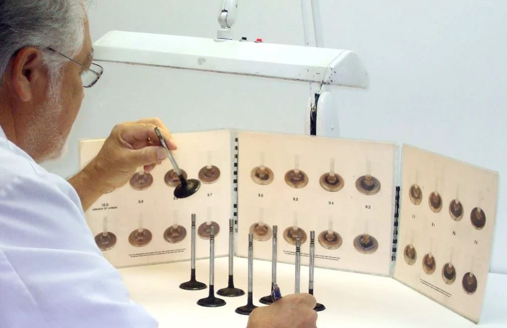 Why Gasoline Has Detergent Additives, And Why More Detergent ISN'T Necessarily Better 19 Photo of a white-coated scientist examining the deposits on a series of intake valves