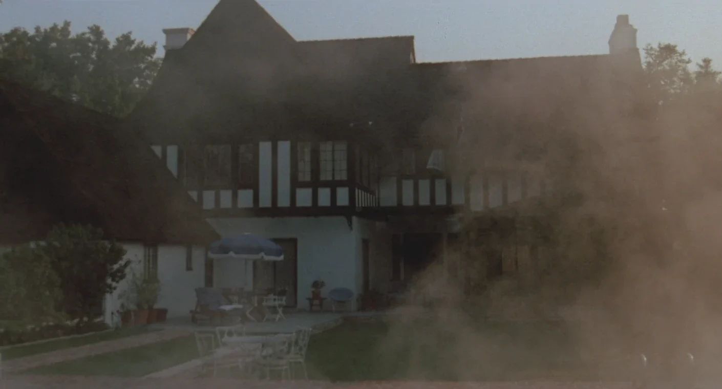 Why The 1972 Lincoln Continental Was The Perfect Movie Costar In This Jack Lemmon Drama 4 Movie screenshot of a large house partly obscured by steam rising from a heated pool