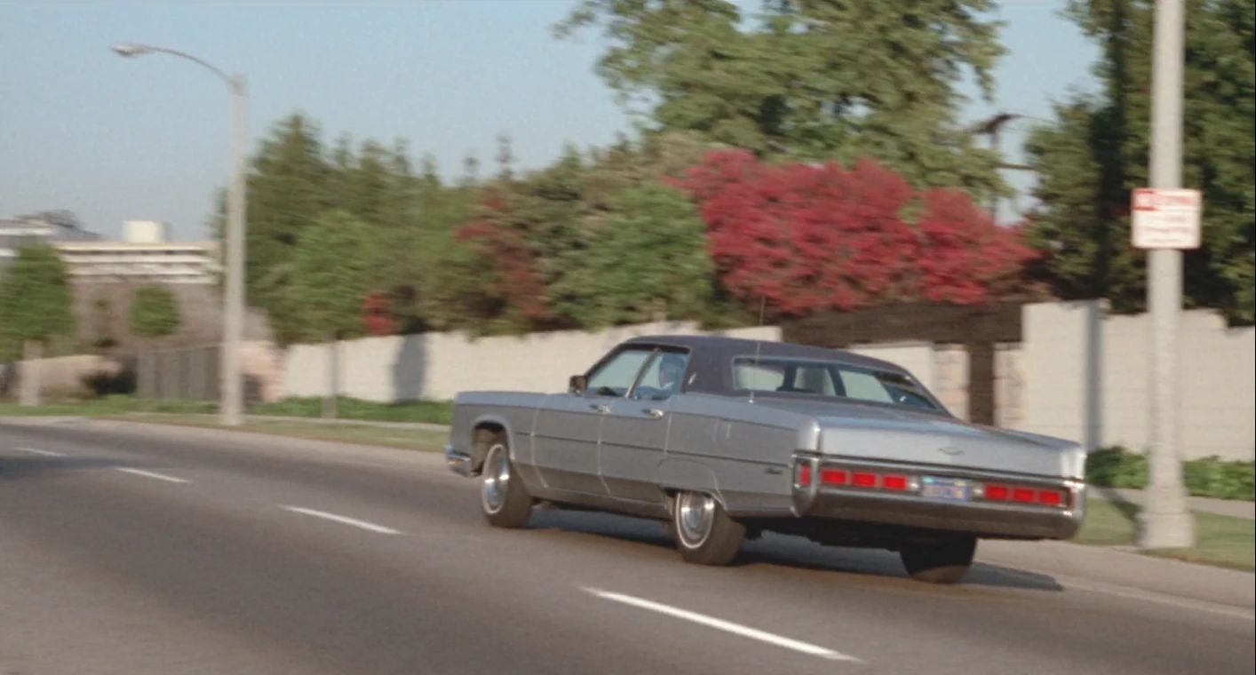 Why The 1972 Lincoln Continental Was The Perfect Movie Costar In This Jack Lemmon Drama 7 Movie screenshot of a light gray metallic 1972 Lincoln Continental sedan driving down a Los Angeles street