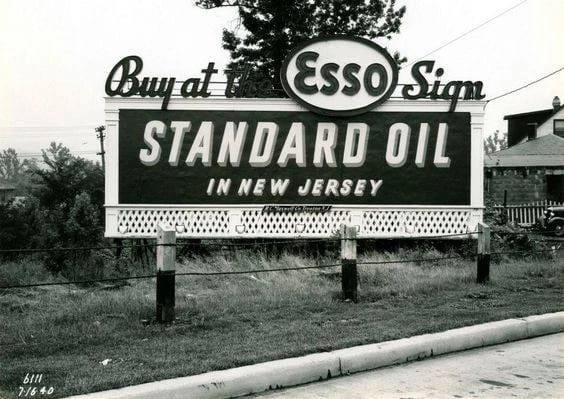 B&W photo of a sign reading "Buy at the Esso Sign: Standard Oil in New Jersey"