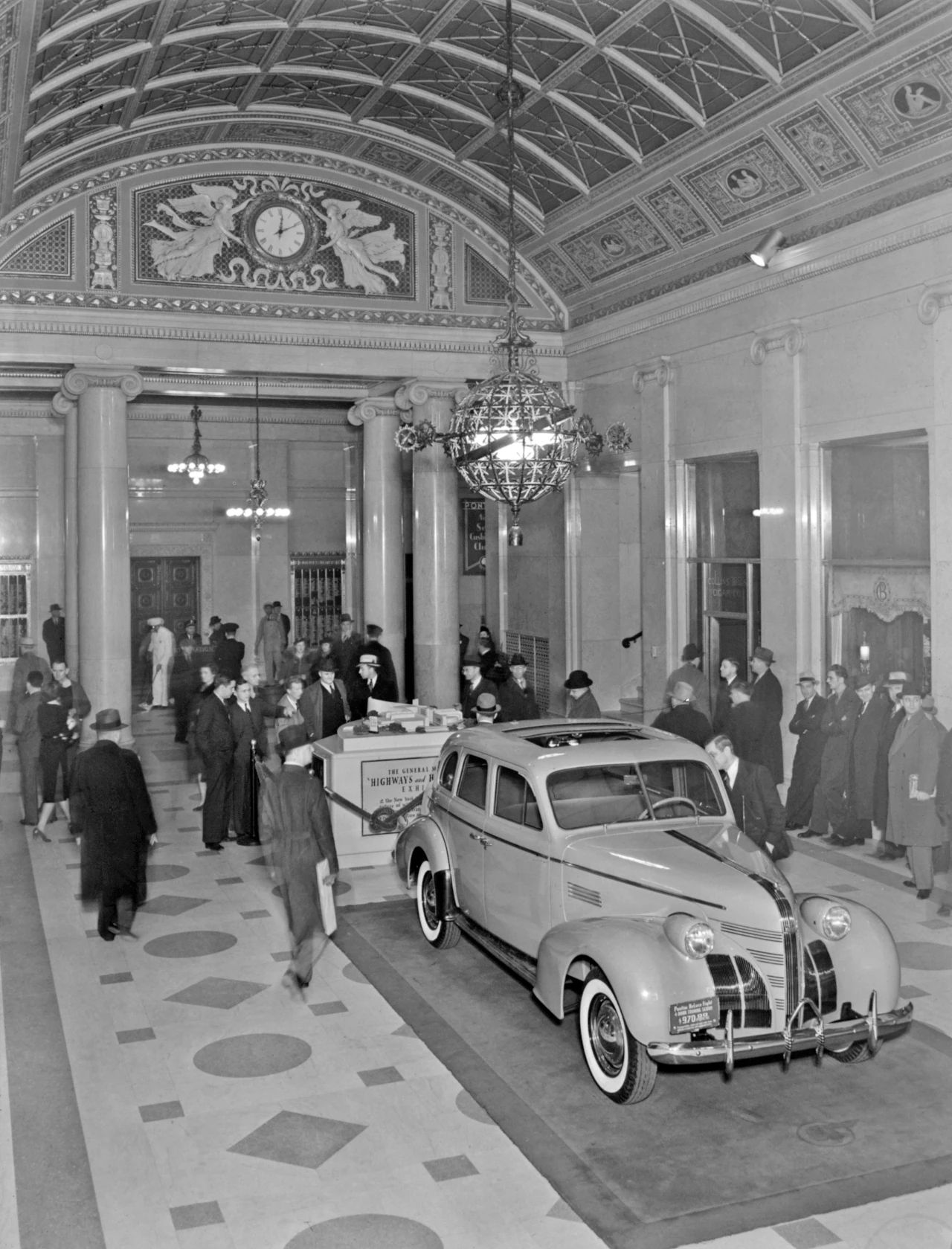 B&W photo of a 1939 Pontiac on display in a lobby at the New York World's Fair