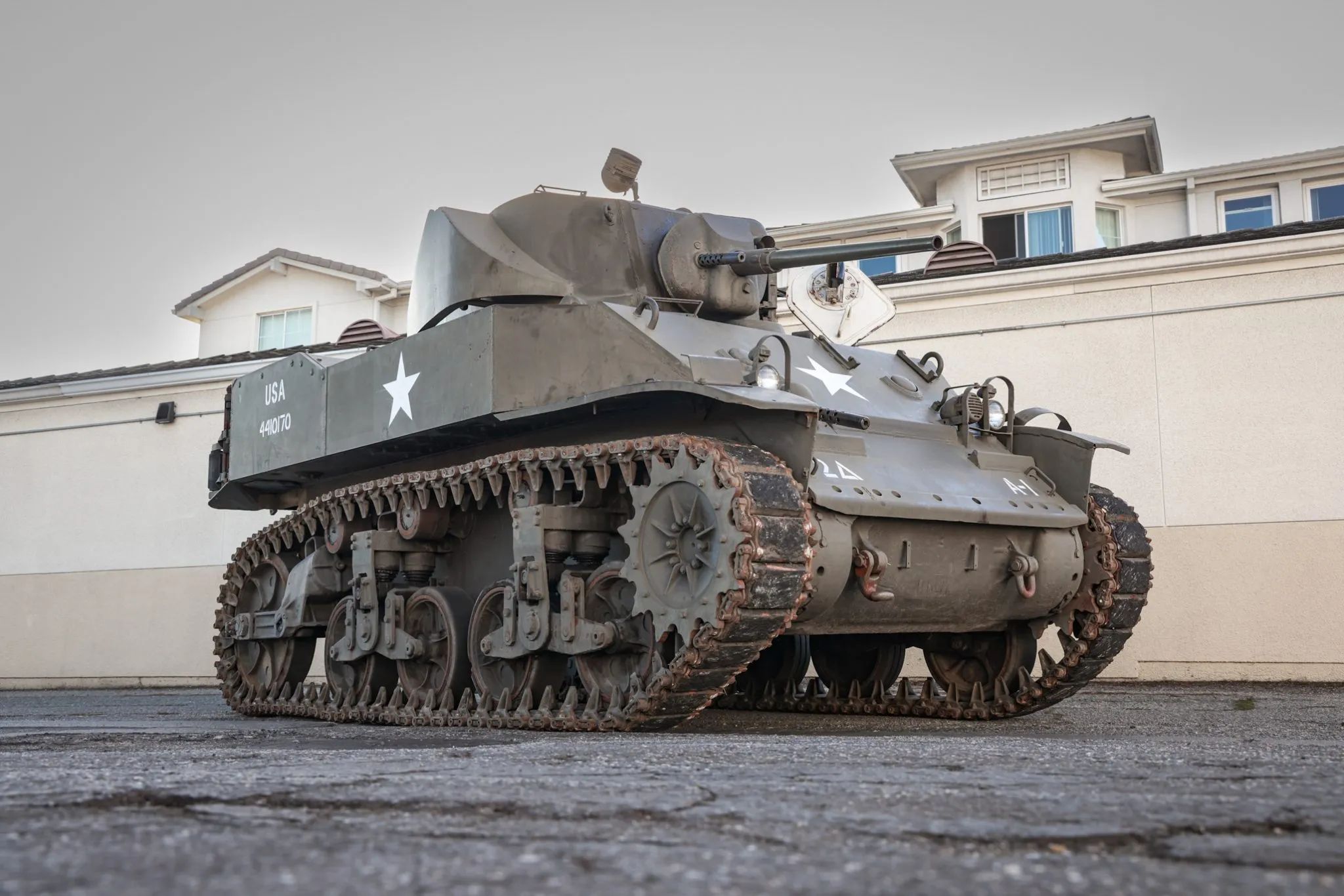 This WW2 Tank Is Powered By Twin Cadillac Engines And Hydra-Matic Transmissions, And It Was Parked Down The Street 2 Low-angle right front 3q view of an olive drab light tank