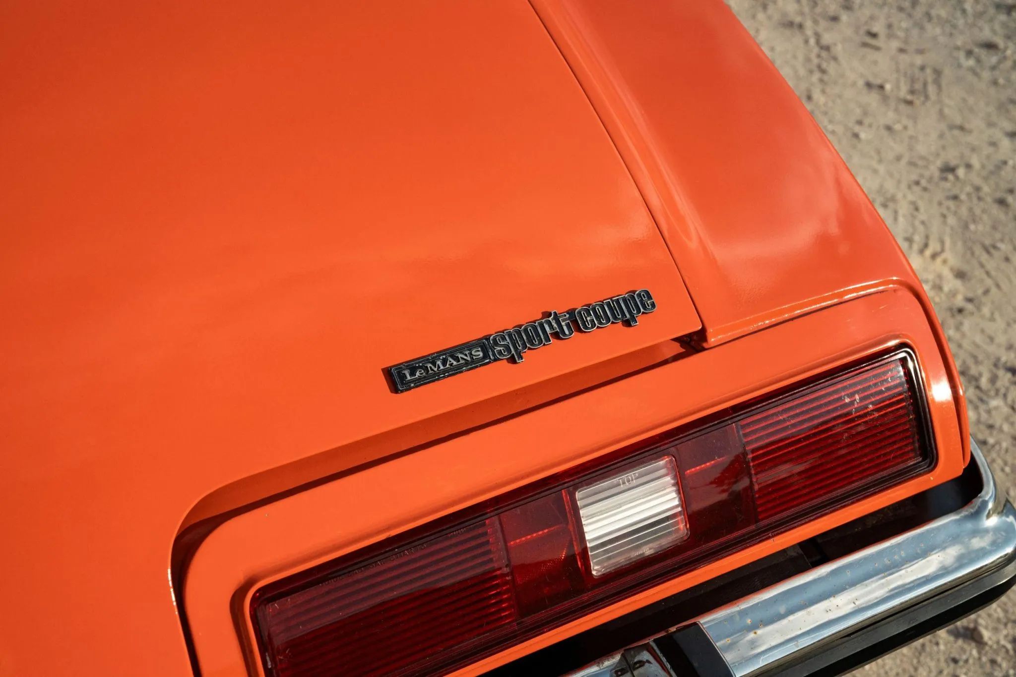 1973 Pontiac LeMans Sport Coupe: The Poor Man's GTO, With A 3-Speed Manual Transmission 7 "sport coupe" badge on the rear deck of an orange 1973 Pontiac