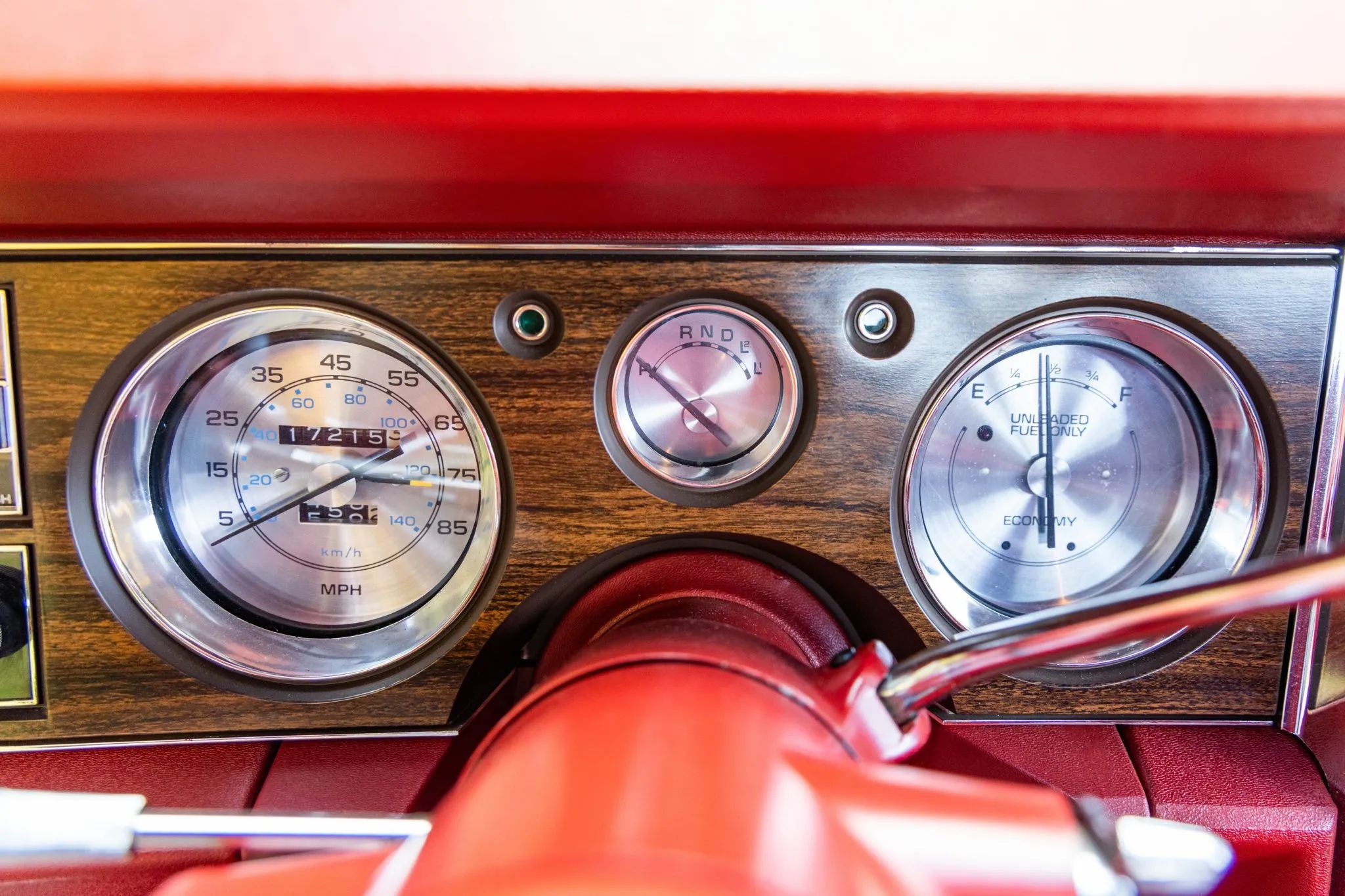 Instrument panel of a 1977 Buick, with bright metal gauge faces in a simulated wood panel