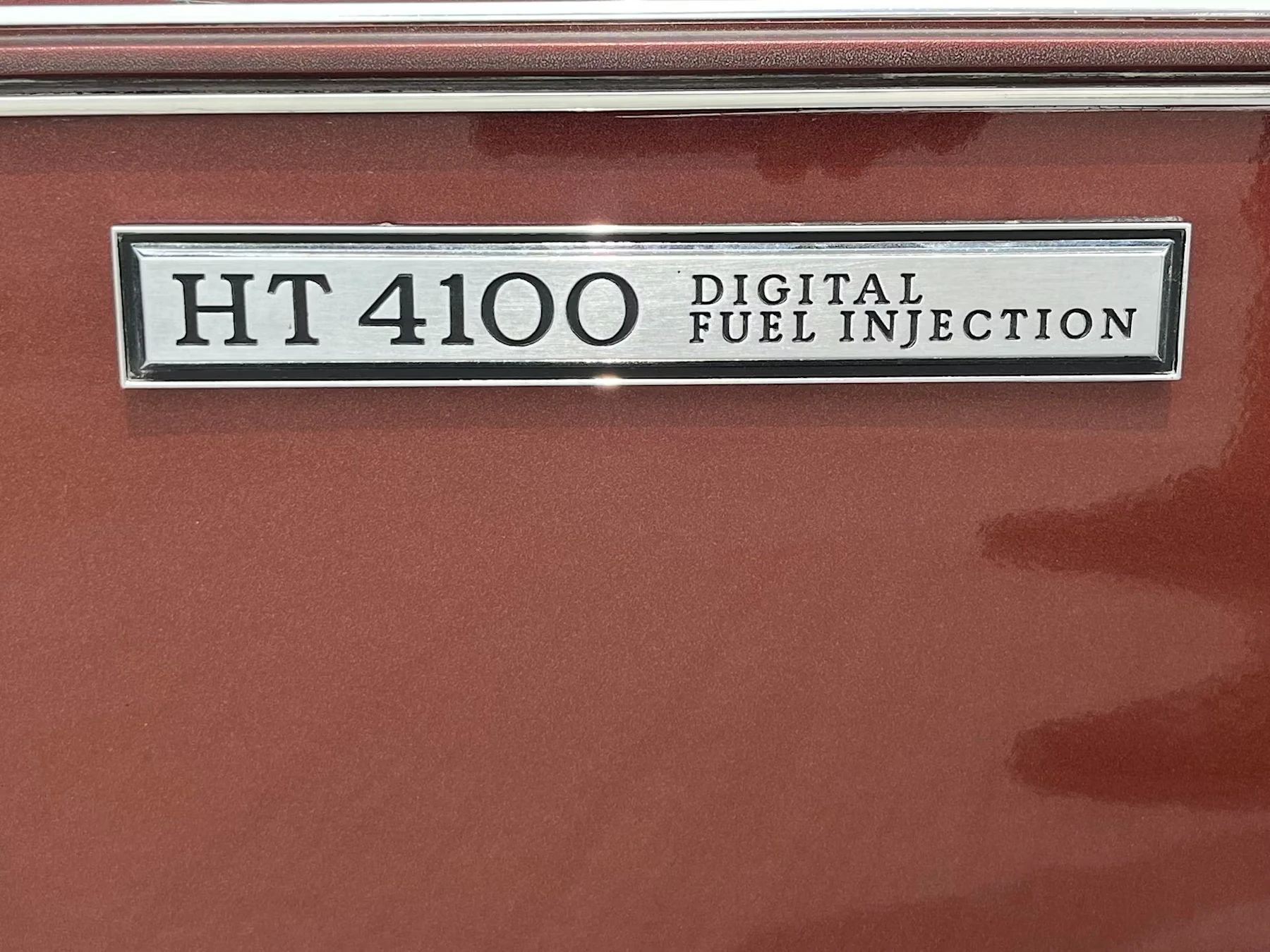 "HT4100 Digital Fuel Injection" badge on a brown 1982 Cadillac