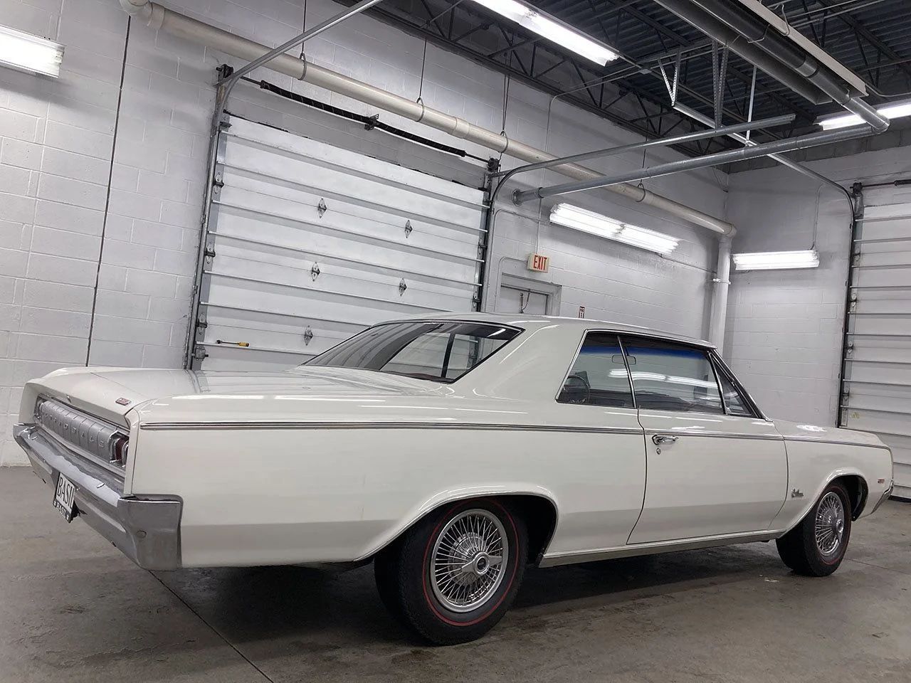 Left rear 3q view of a white 1964 Olds Cutlass in a garage