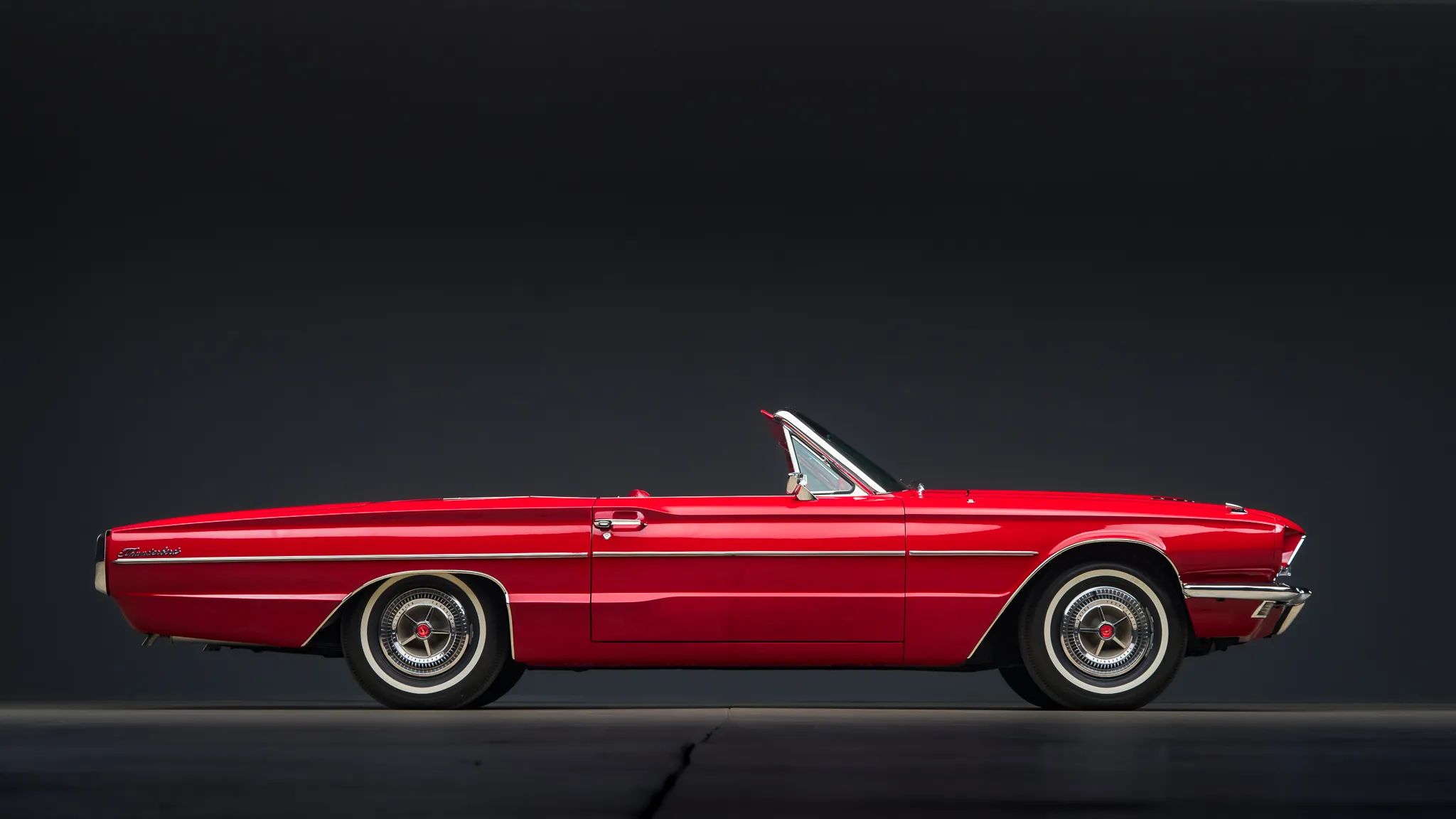 1966 Ford Thunderbird: Dream Car With A Space Age Interior To Let Your Inner Child Take Flight 5 Right side view of a 1966 Thunderbird convertible with the top down, in a studio space against a black background