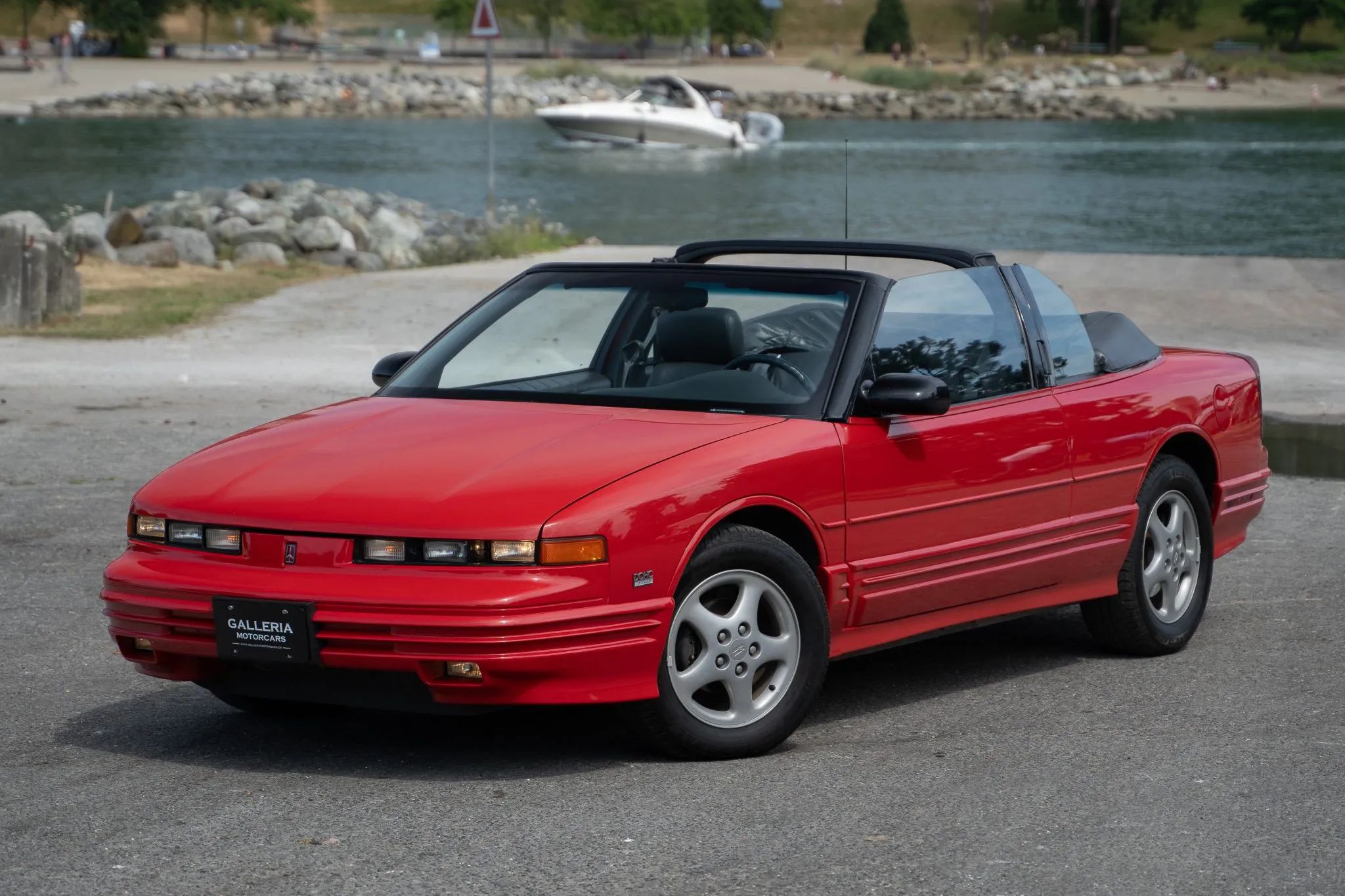 High-angle left front 3q view of a 1995 Oldsmobile Cutlass Supreme convertible with the top down