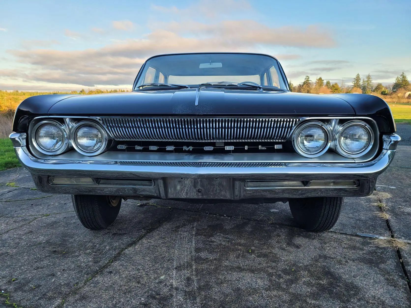 Front view of a 1961 Oldsmobile Dynamic 88, with "OLDSMOBILE" lettering in the grille