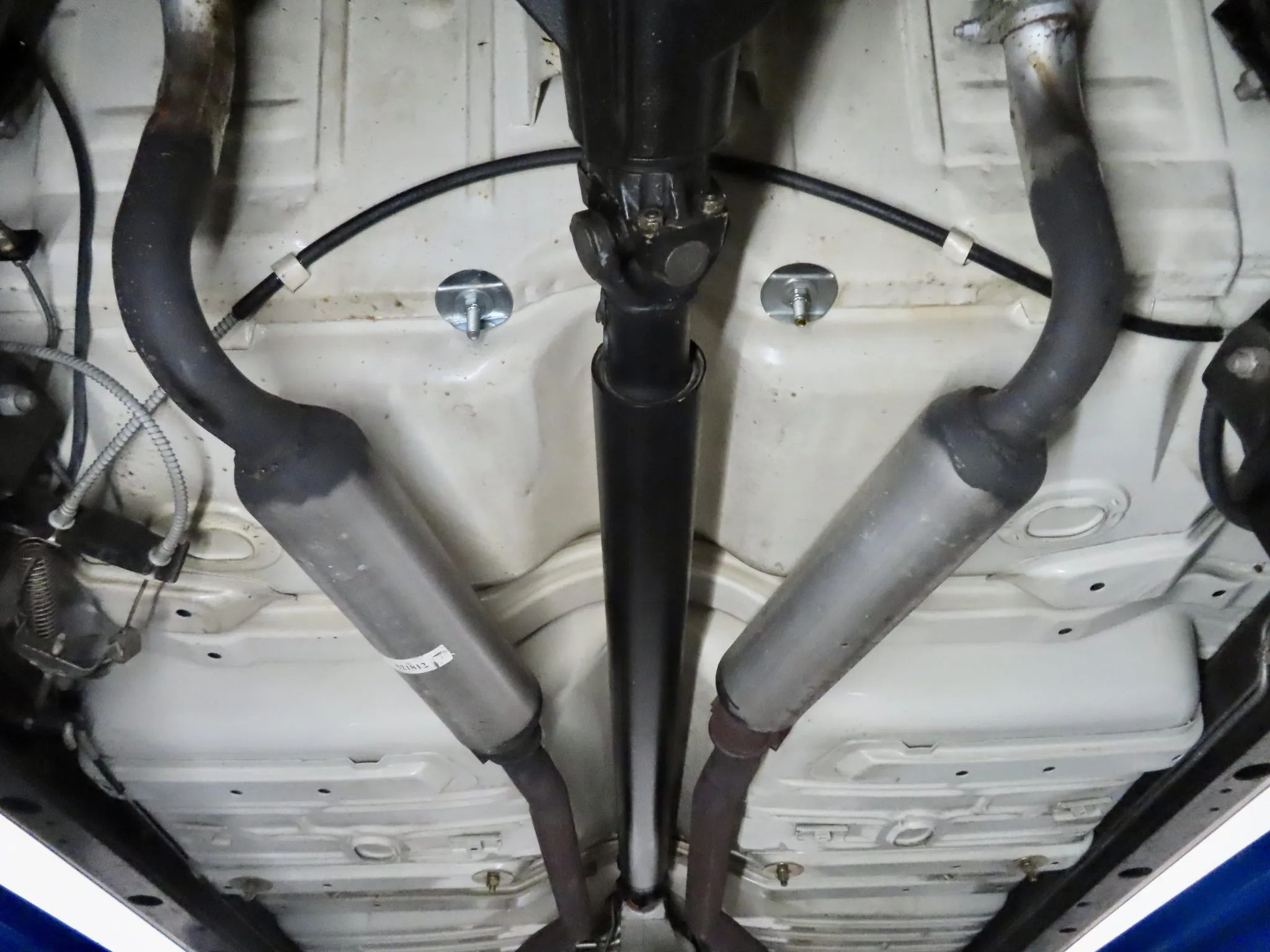 Exhaust pipes and resonators under a 1962 Oldsmobile