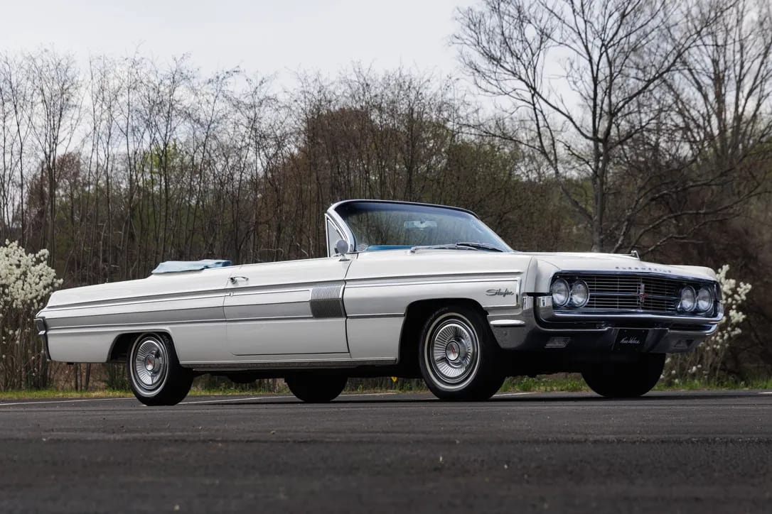 Right front 3q view of a 1962 Oldsmobile Starfire convertible with the top down