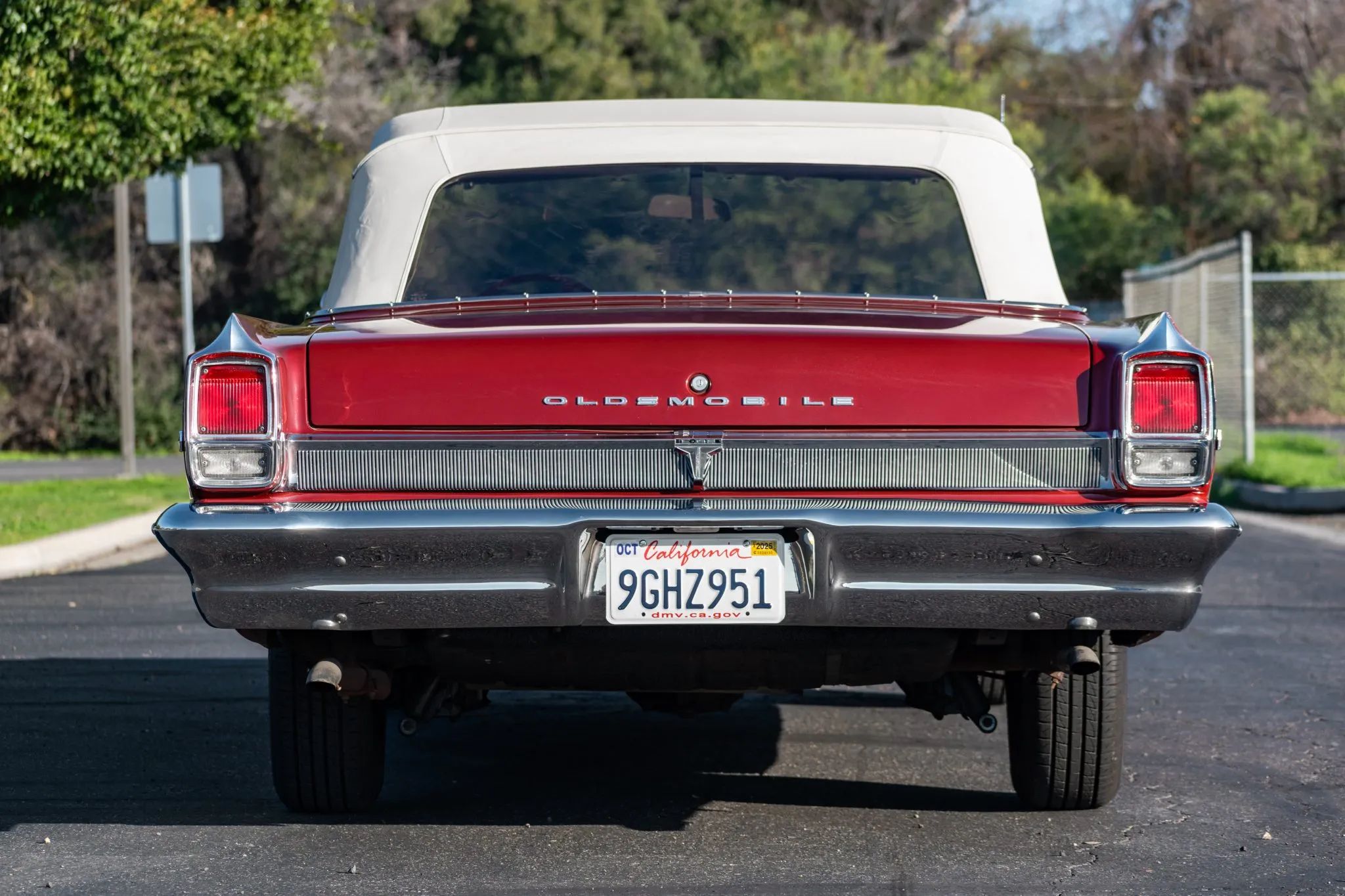 Rear view of a Regal Mist 1963 Oldsmobile Cutlass convertible with its top up