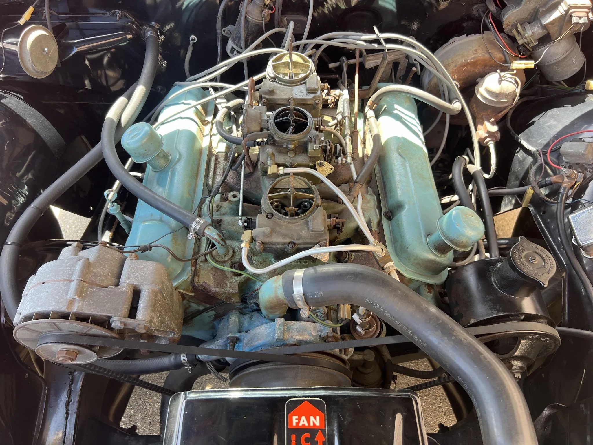 Three carburetors on a Pontiac V-8 with its air cleaner removed