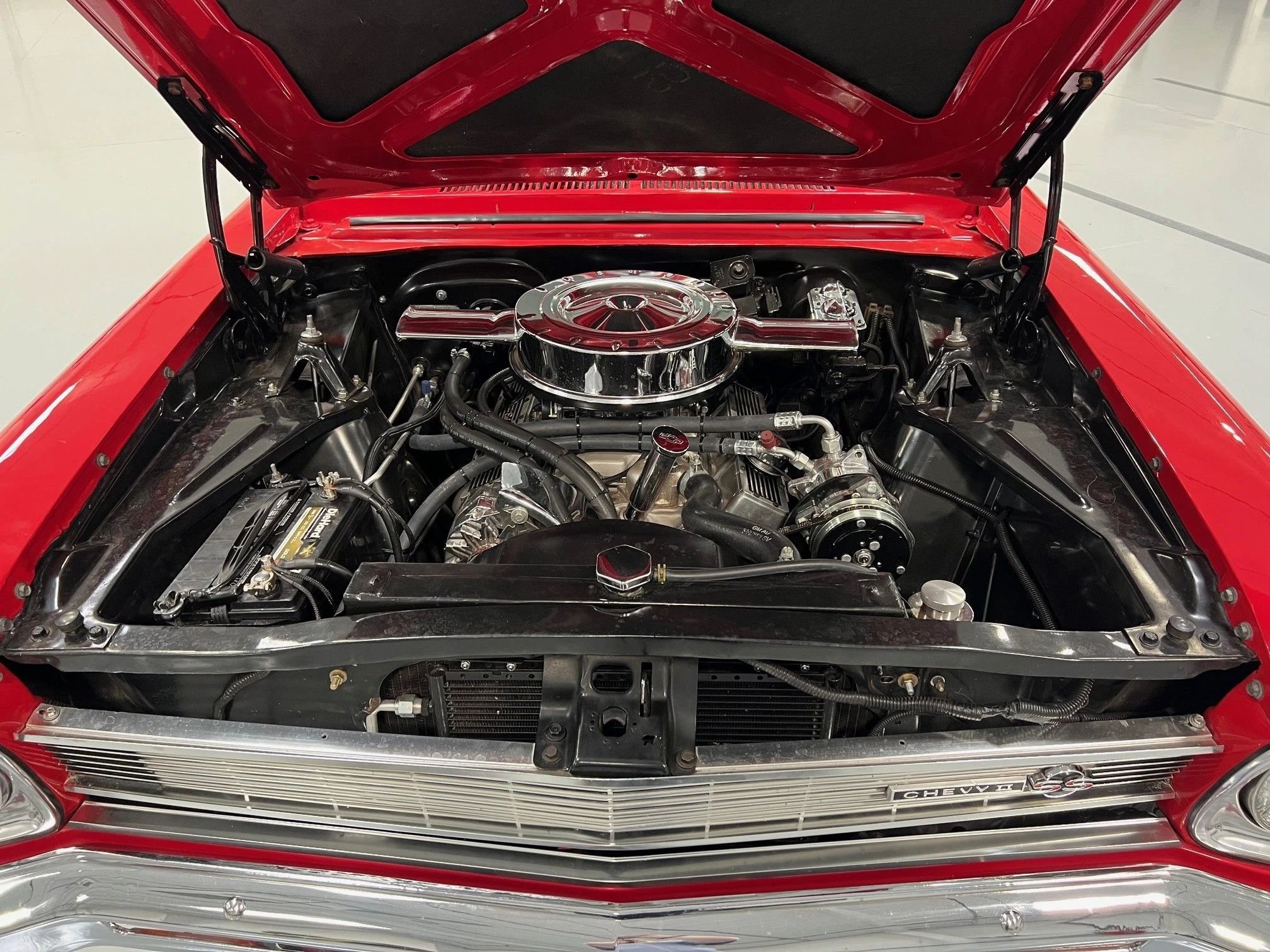 V-8 engine with a dual-snorkel air cleaner in a red 1966 Chevrolet Nova SS