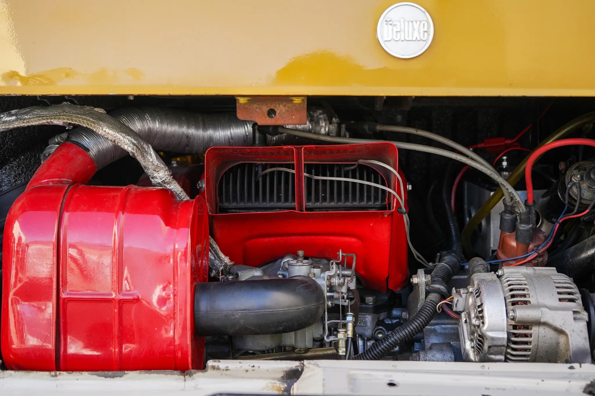 Rear view of a two-cylinder Subaru engine, showing the red cooling fan intake