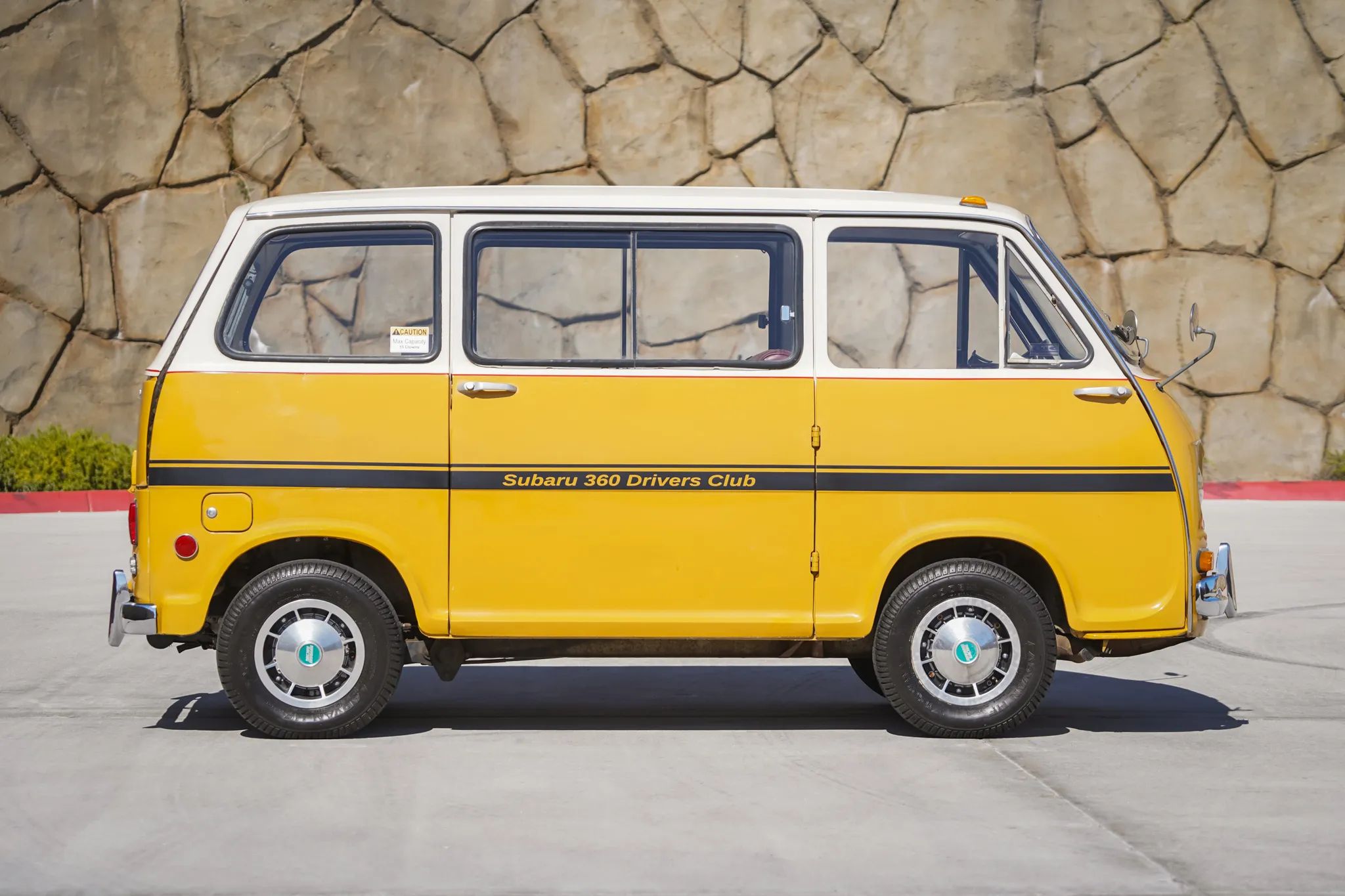 Right side view of a white and orange 1969 Subaru keitora van
