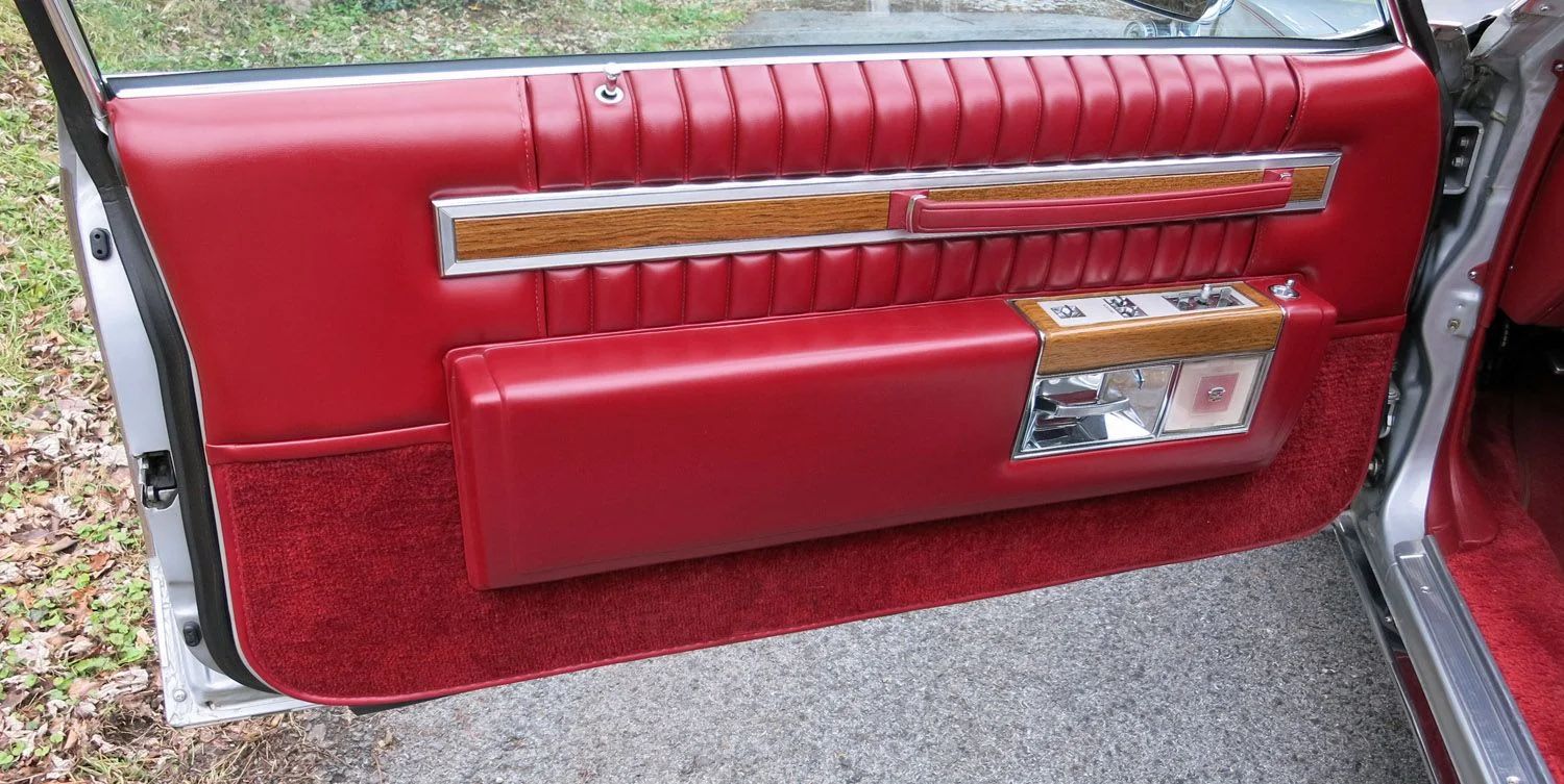 Driver's door trim of a 1981 Cadillac with red upholstery