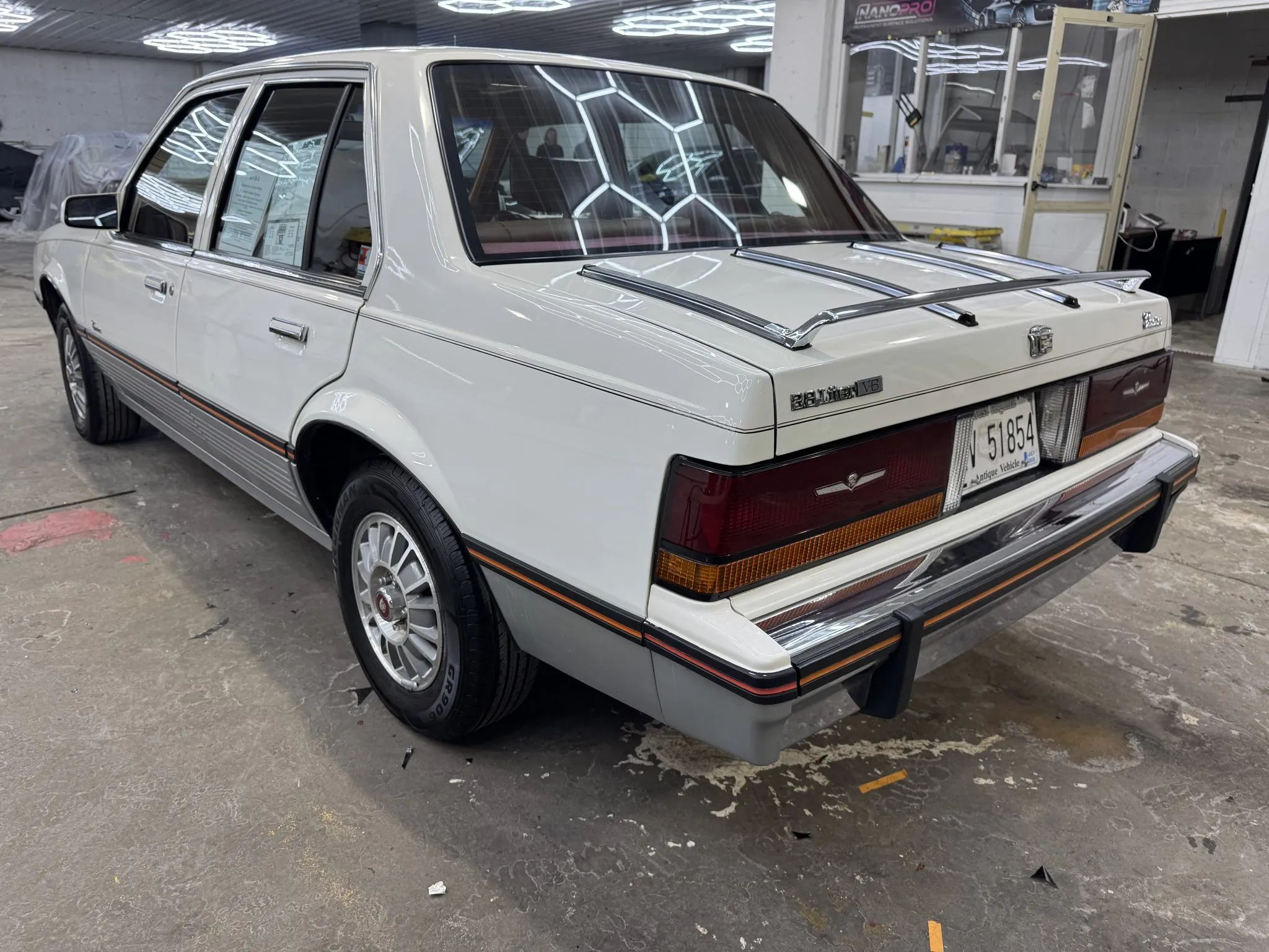 Driver's rear three-quarter view of white 1986 Cadillac Cimarron