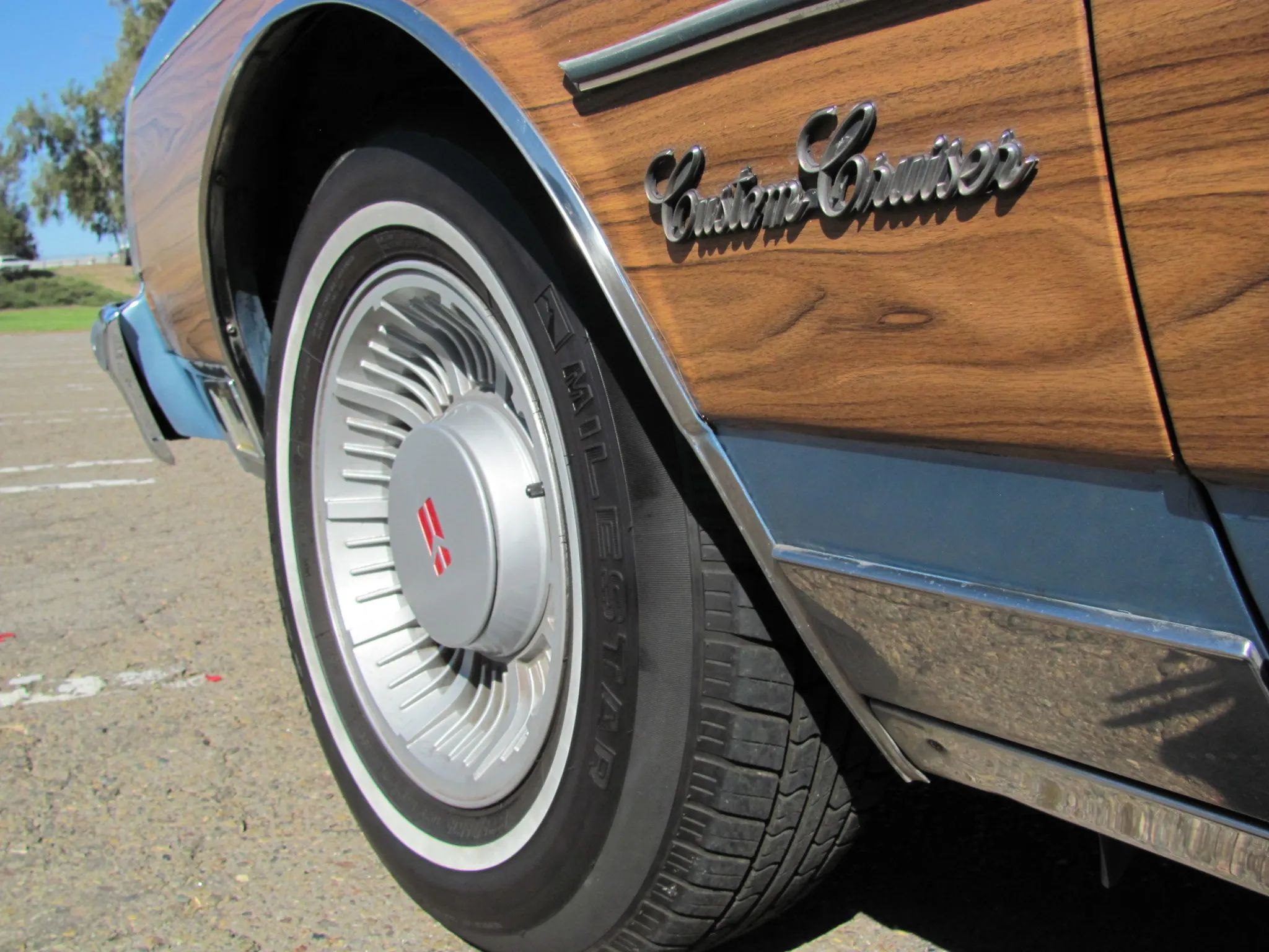 Closeup of the "Custom Cruiser" badge of a 1990 Oldsmobile with fake wood side trim