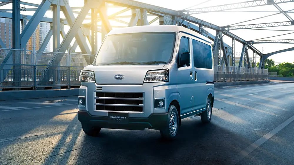 Press image of a silver Subaru Sambar van on a bridge