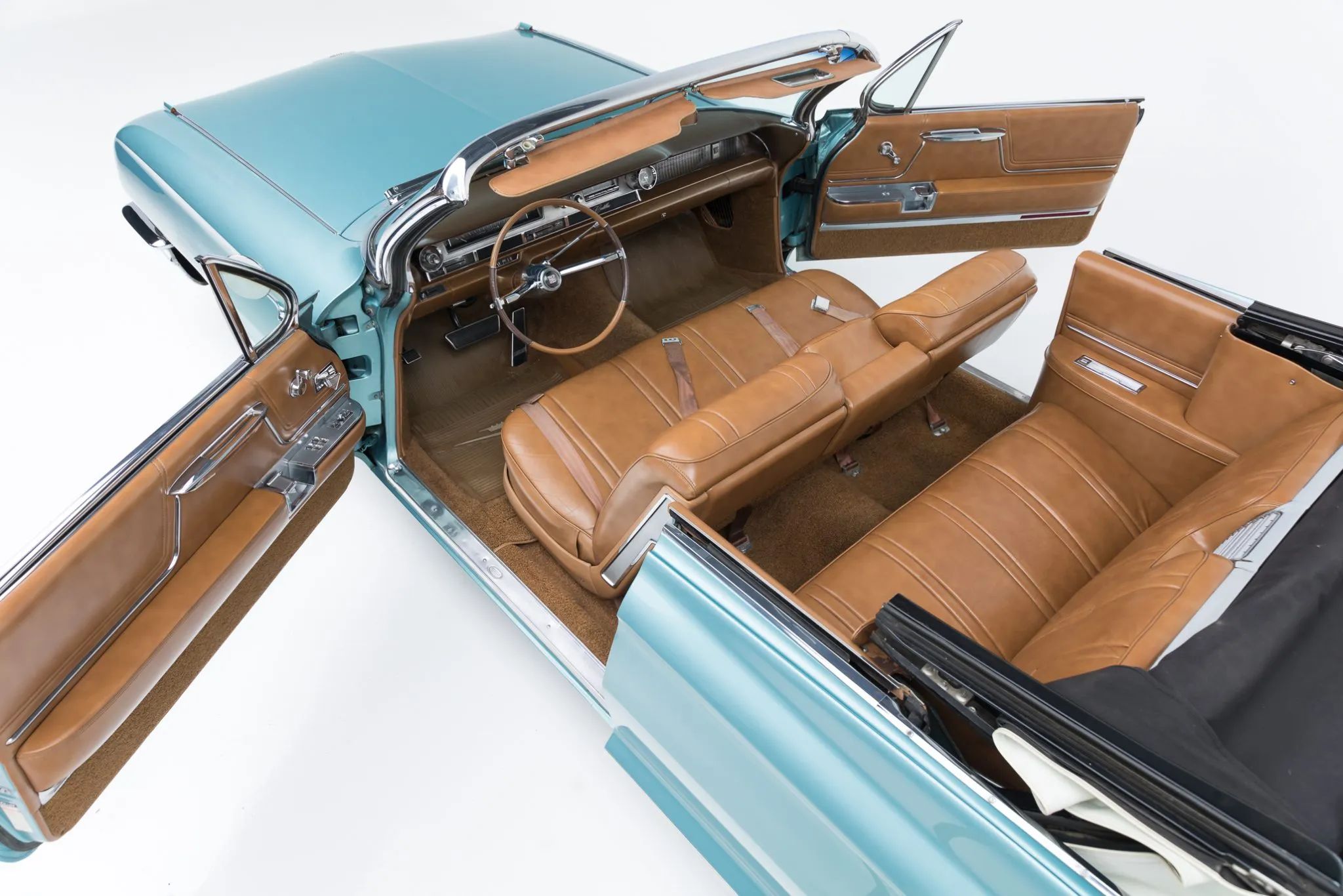 High-angle overhead shot of a 1962 Cadillac convertible with the top down and the doors open