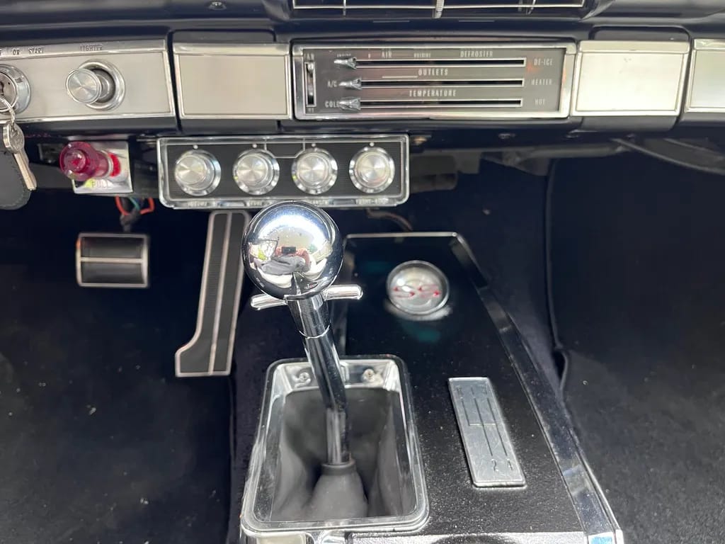 1965 Chevrolet Impala SS 409 4-Speed: In The Cool, Cool, Cool Of The Evening Orchid 13 Shifter in the console of a 1965 Chevrolet, which some switches under the dashboard above it