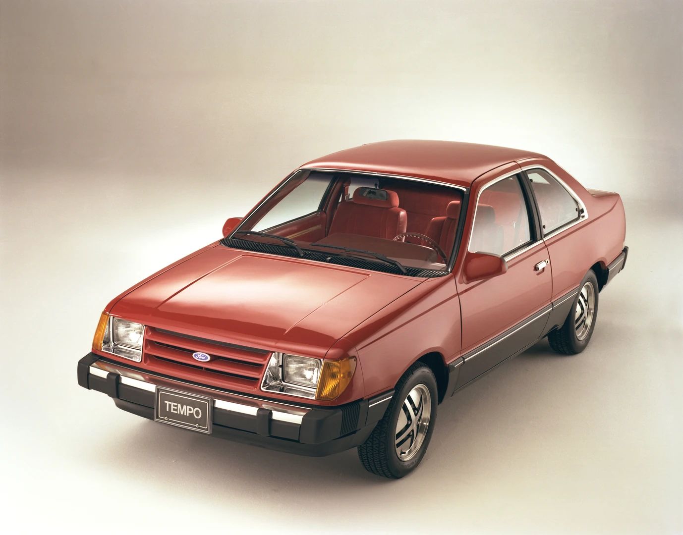 Studio shot of a red 1983 Ford Tempo