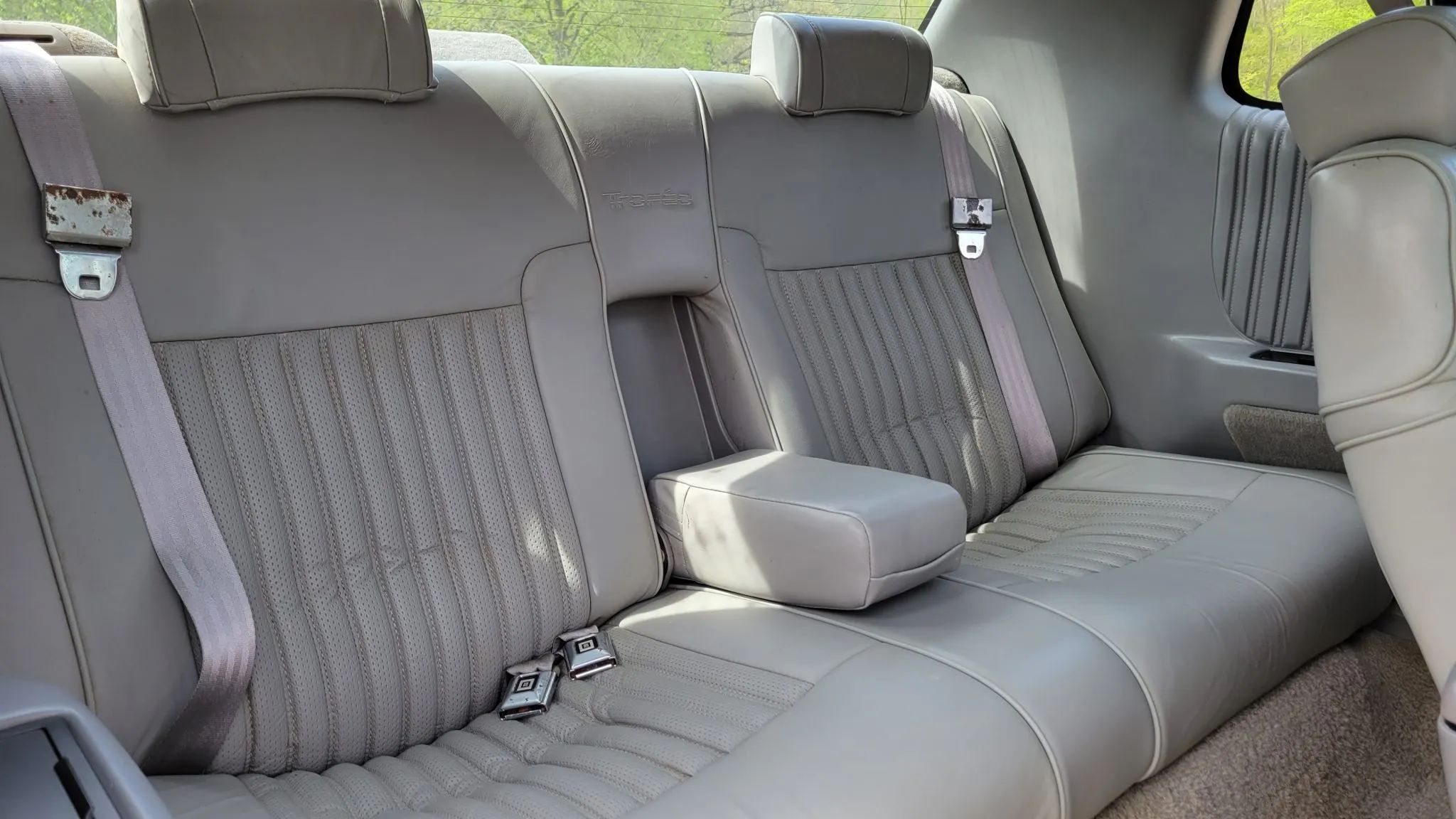 Back seat of a 1992 Toronado with the center armrest folded down; it's very small