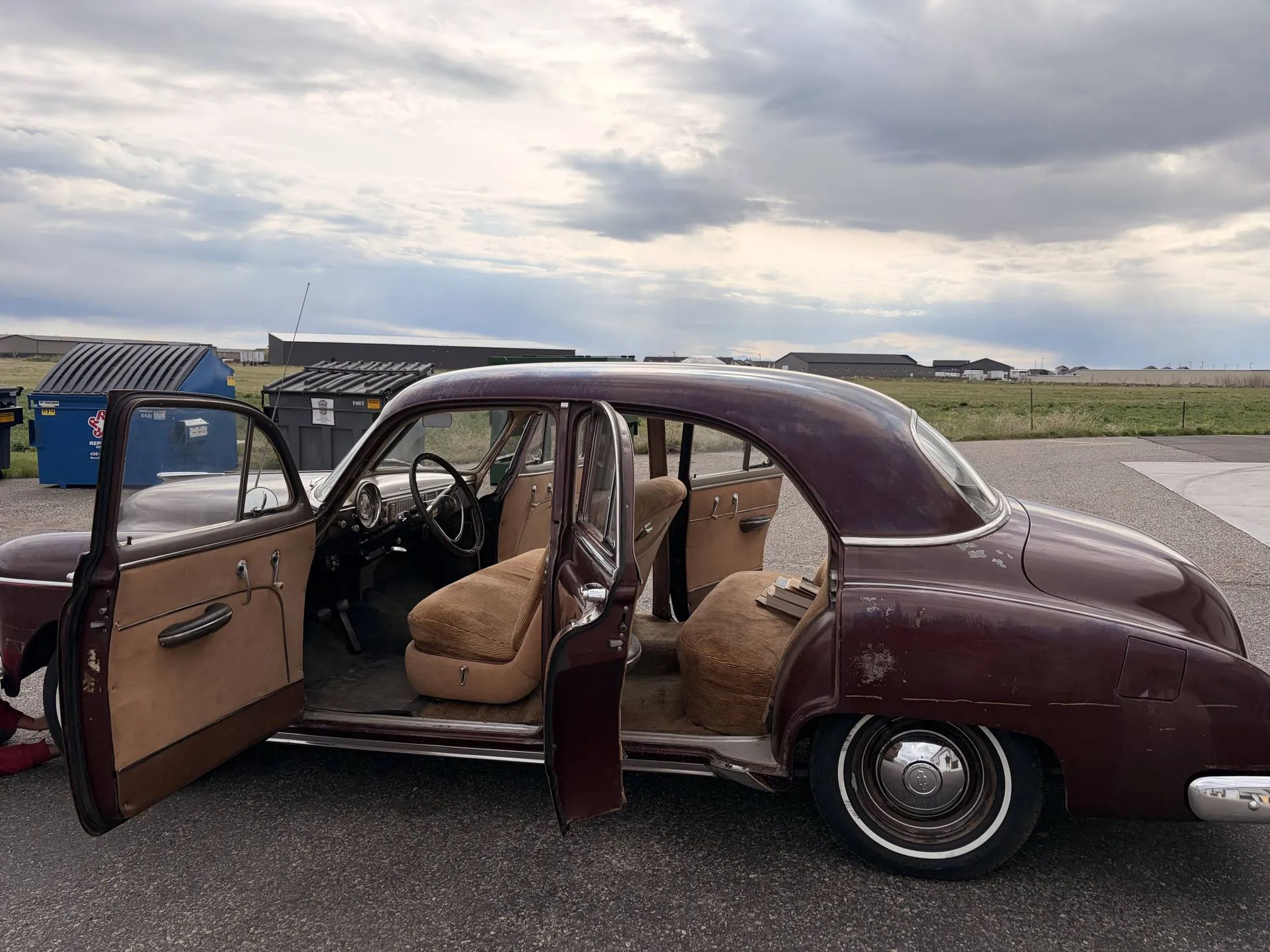 Driver's side view of maroon 1949 Chevrolet sedan with doors open