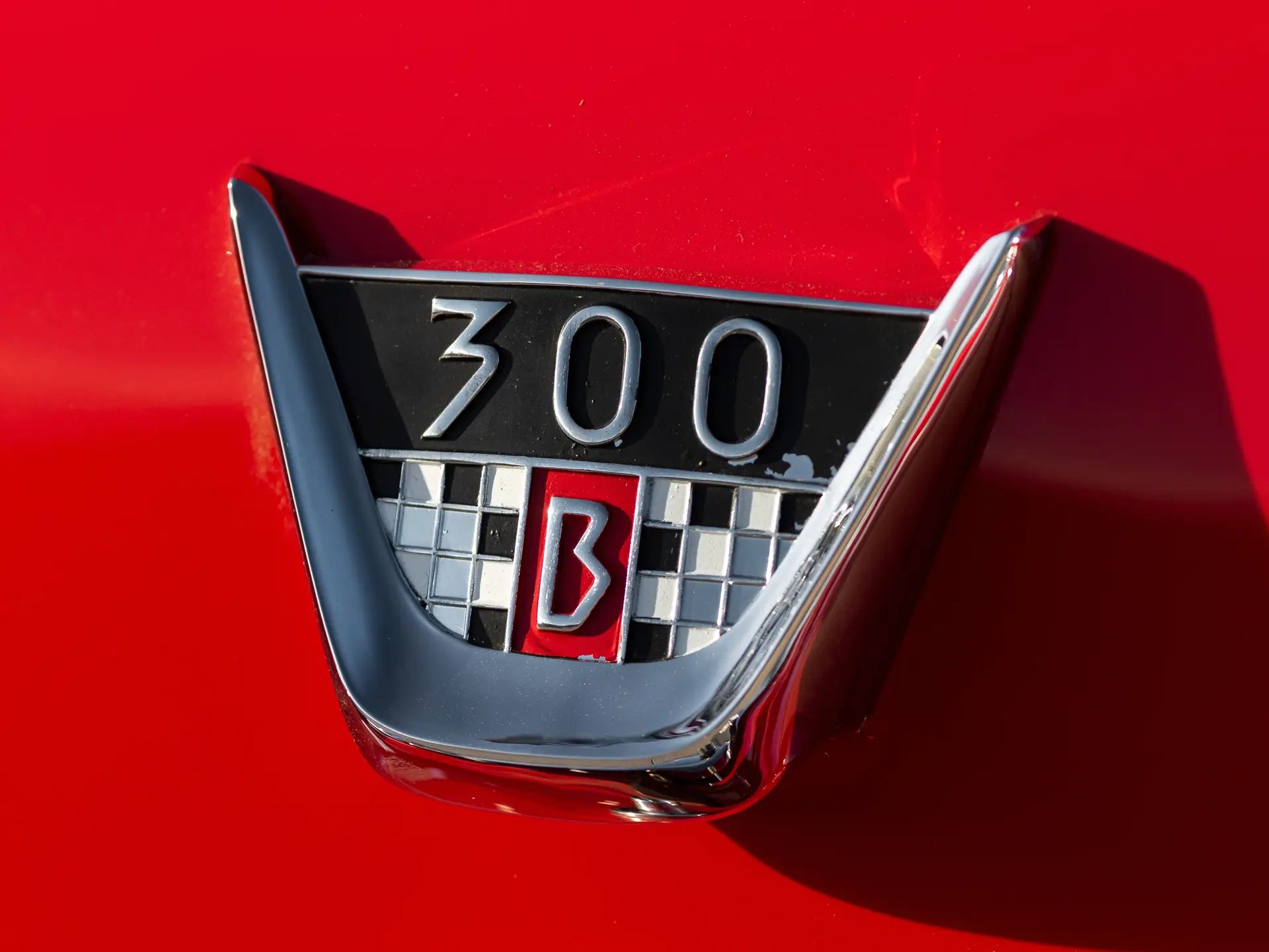 Closeup of a 300 B badge on a red car