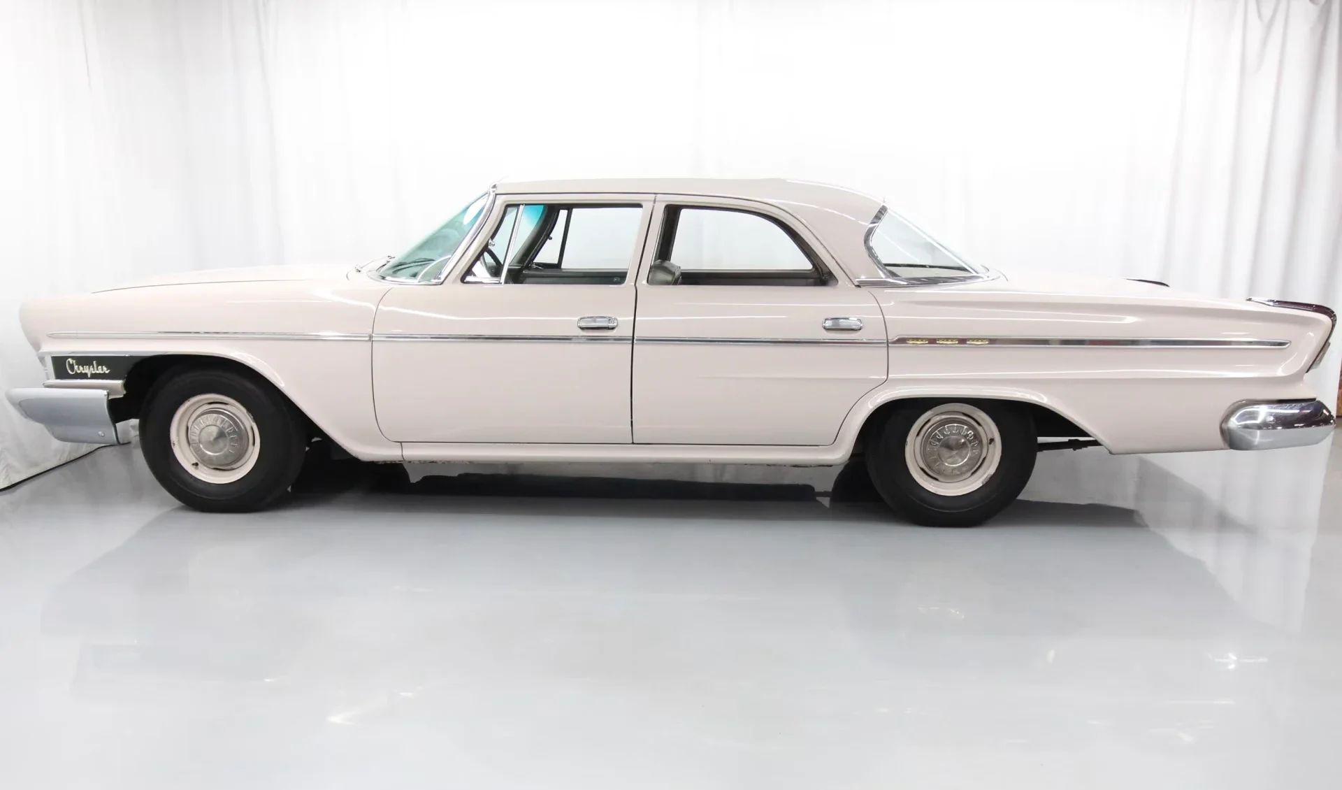 1962 Chrysler Newport 3-Speed Four-Door Sedan: Basic Big Car With An Upscale Badge And Not Much Else 10 Left side view of a 1962 Chrysler four-door sedan in an indoor studio space
