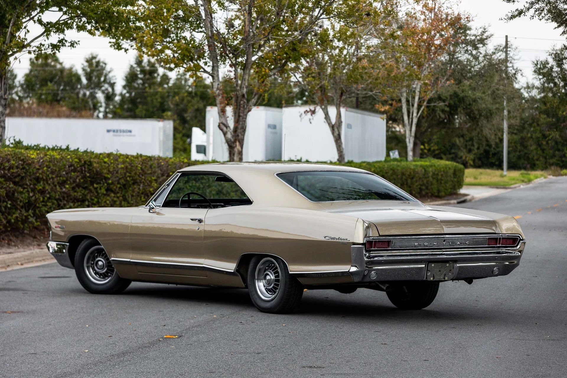 Left rear 3q view of a 1965 Pontiac two-door hardtop parked diagonally in the middle of a street
