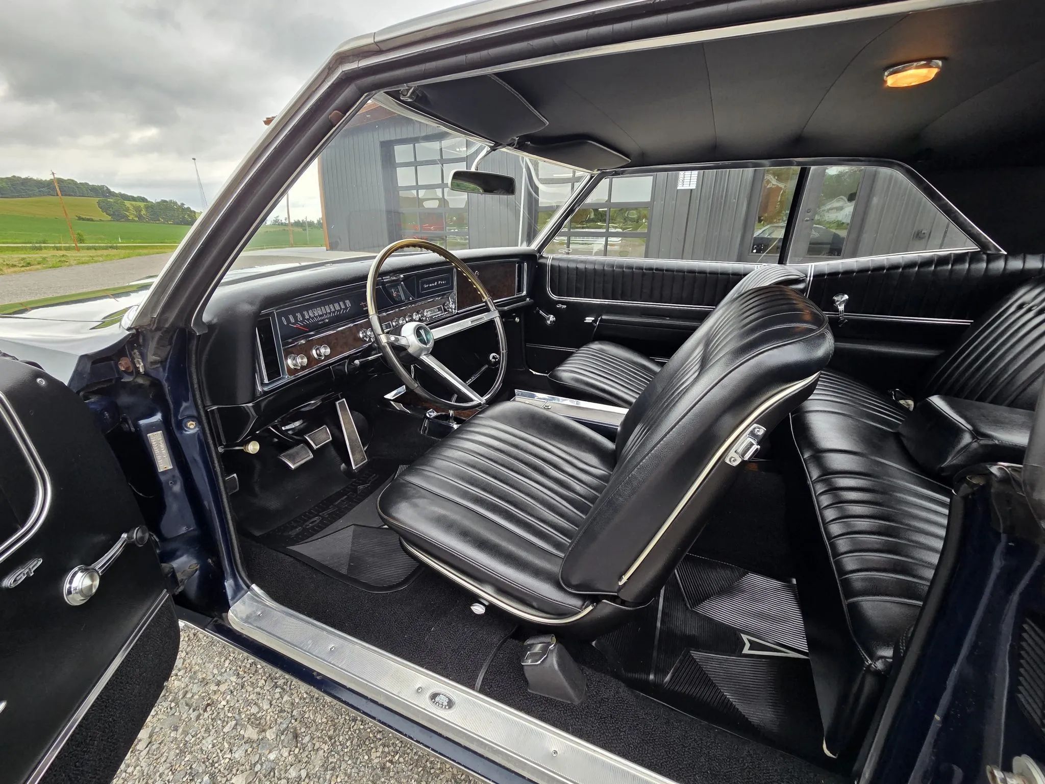 Front seats and dashboard of a 1967 Pontiac Grand Prix, seen through the driver's door