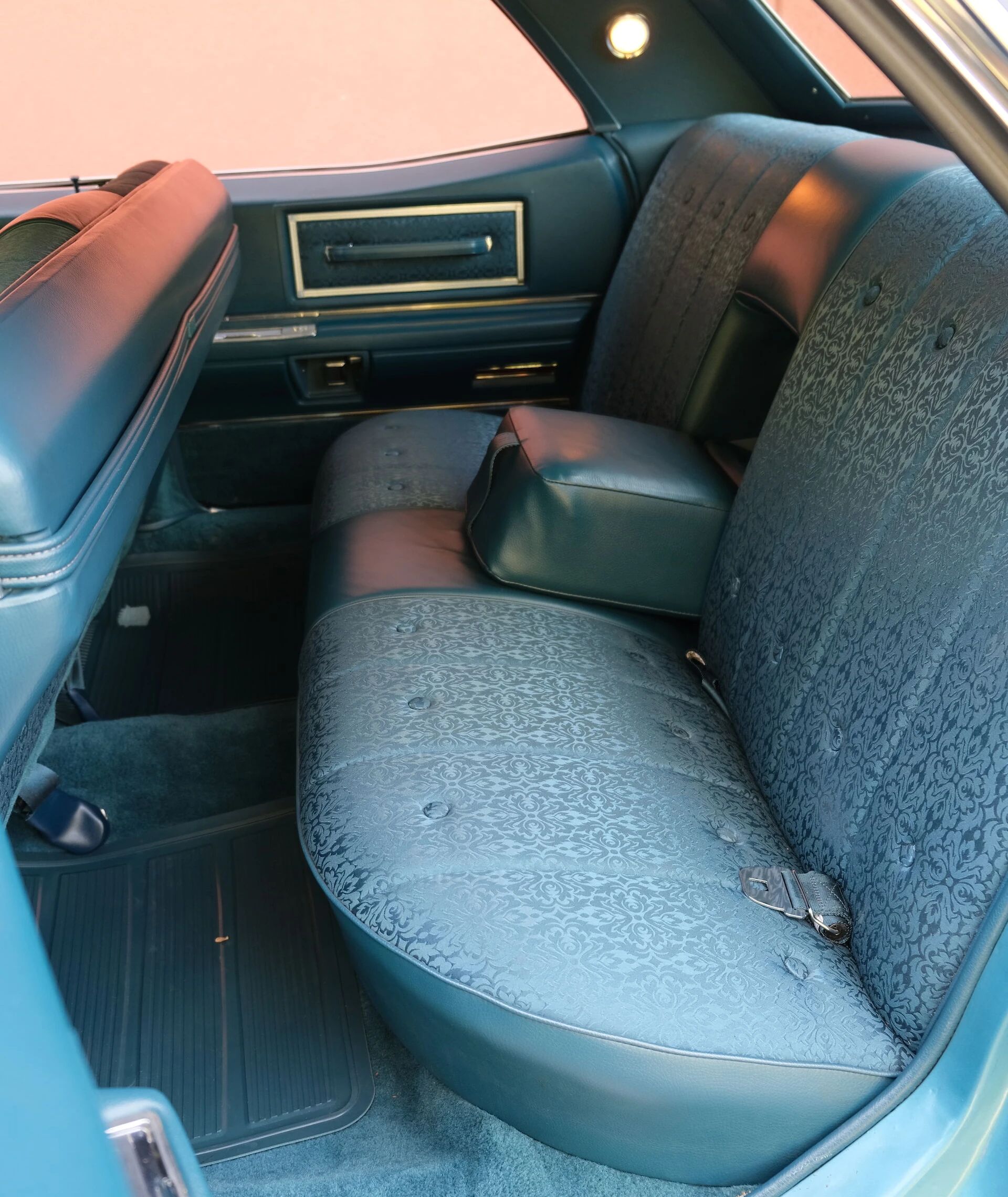Back seat of a 1968 Cadillac four-door hardtop with the center armrest folded down