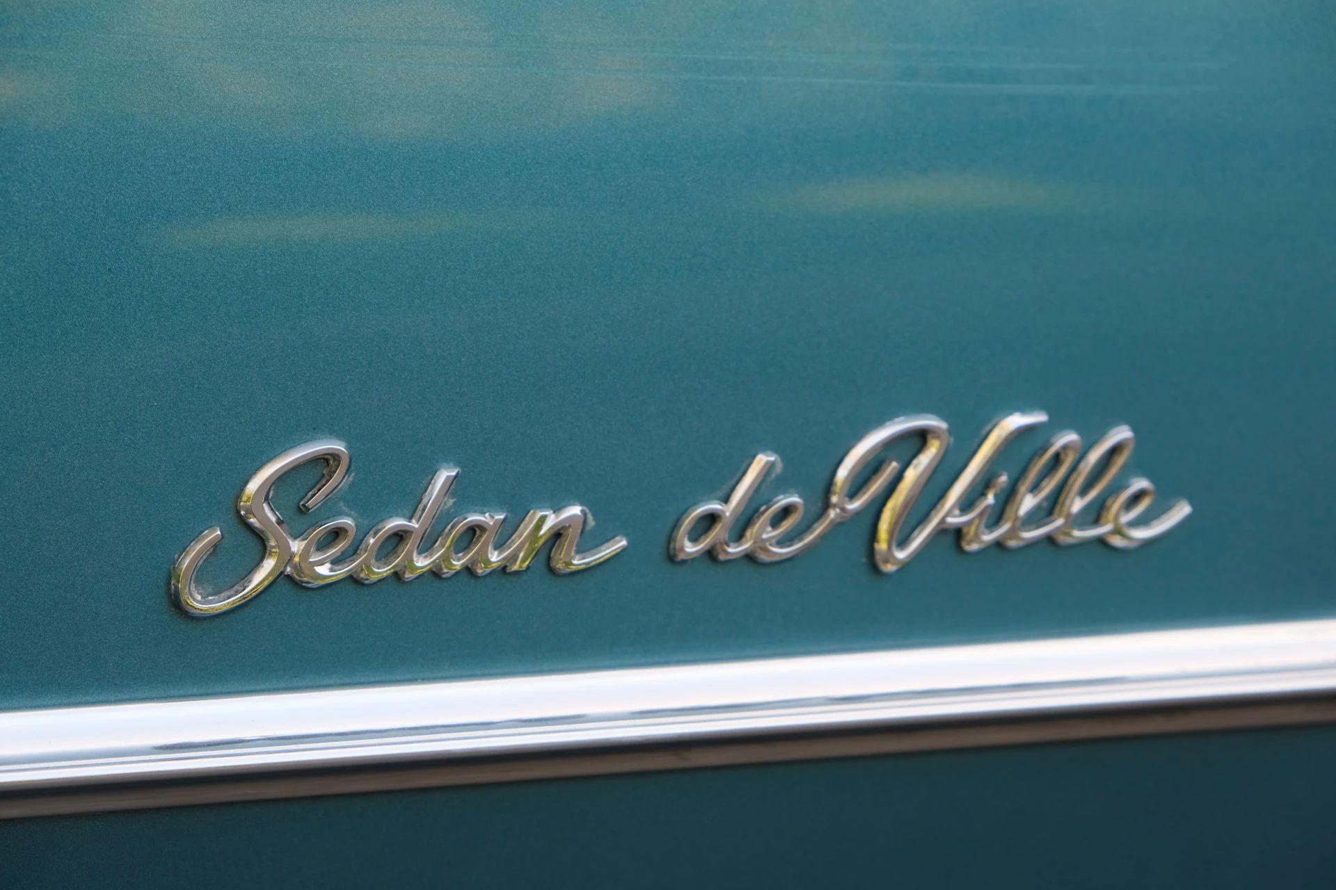 "Sedan de Ville" lettering on an aqua-colored car