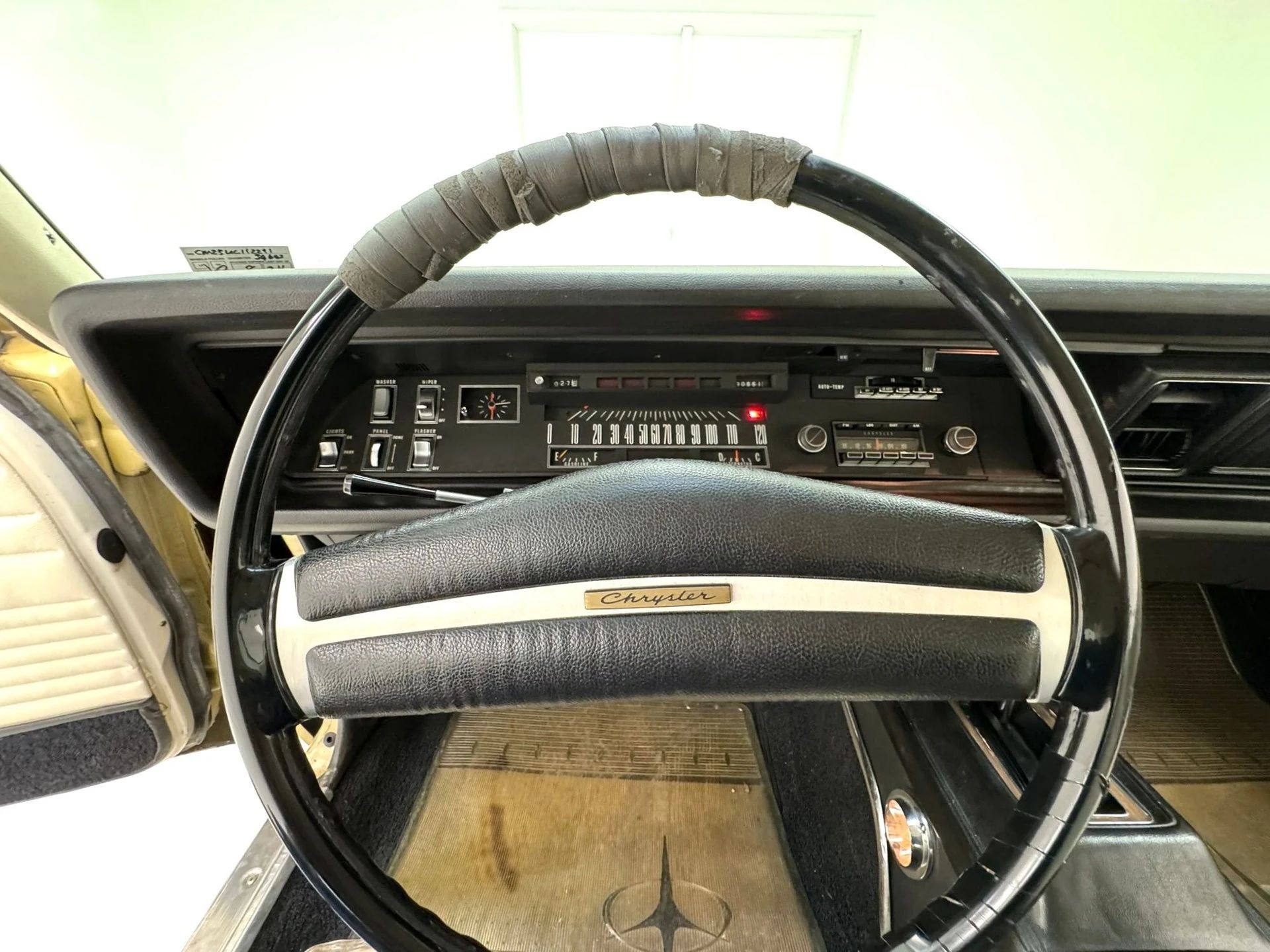 Steering wheel of a 1970 Chrysler; the top of the wheel rim is wrapped with tape
